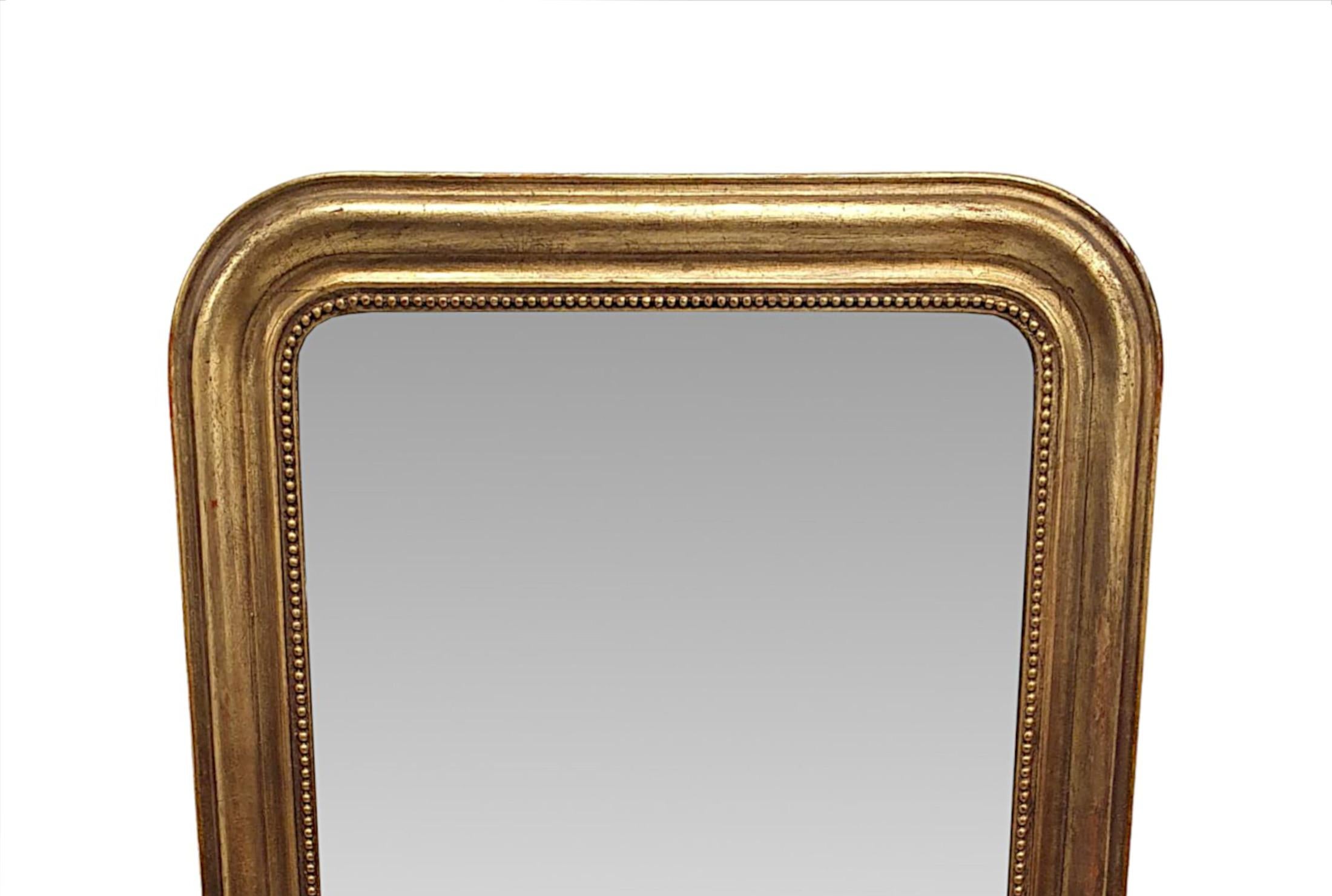 Un beau miroir d'entrée ou de salle de bain en bois doré du 19e siècle, d'une qualité fabuleuse et aux proportions soignées.  La plaque de verre miroir de forme rectangulaire est enchâssée dans un cadre en bois doré finement sculpté à la main,