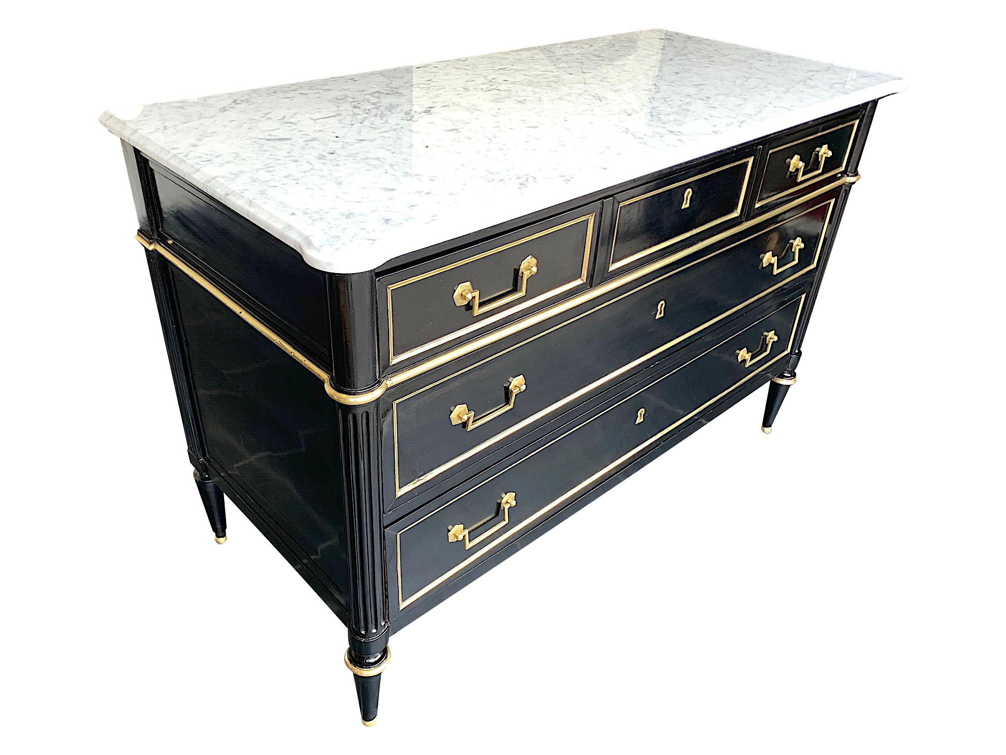 A stunning large sized, Louis XVI style ebonized three drawer commode with brass inlaid front, sides and feet with stunning new Carrara marble top with beveled edge and rounded front corners. With all original brass detail pieces and brass key for