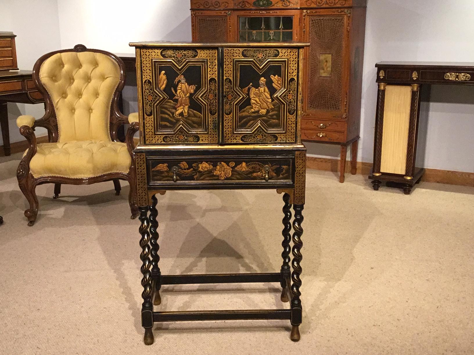 A lovely Edwardian Period chinoiserie lacquered cabinet on Stand. Having a rectangular top with chinoiserie lacquered raised detail with twin shaped panelled doors, above a rectangular oak lined frieze drawer with typical raised lacquered detail.