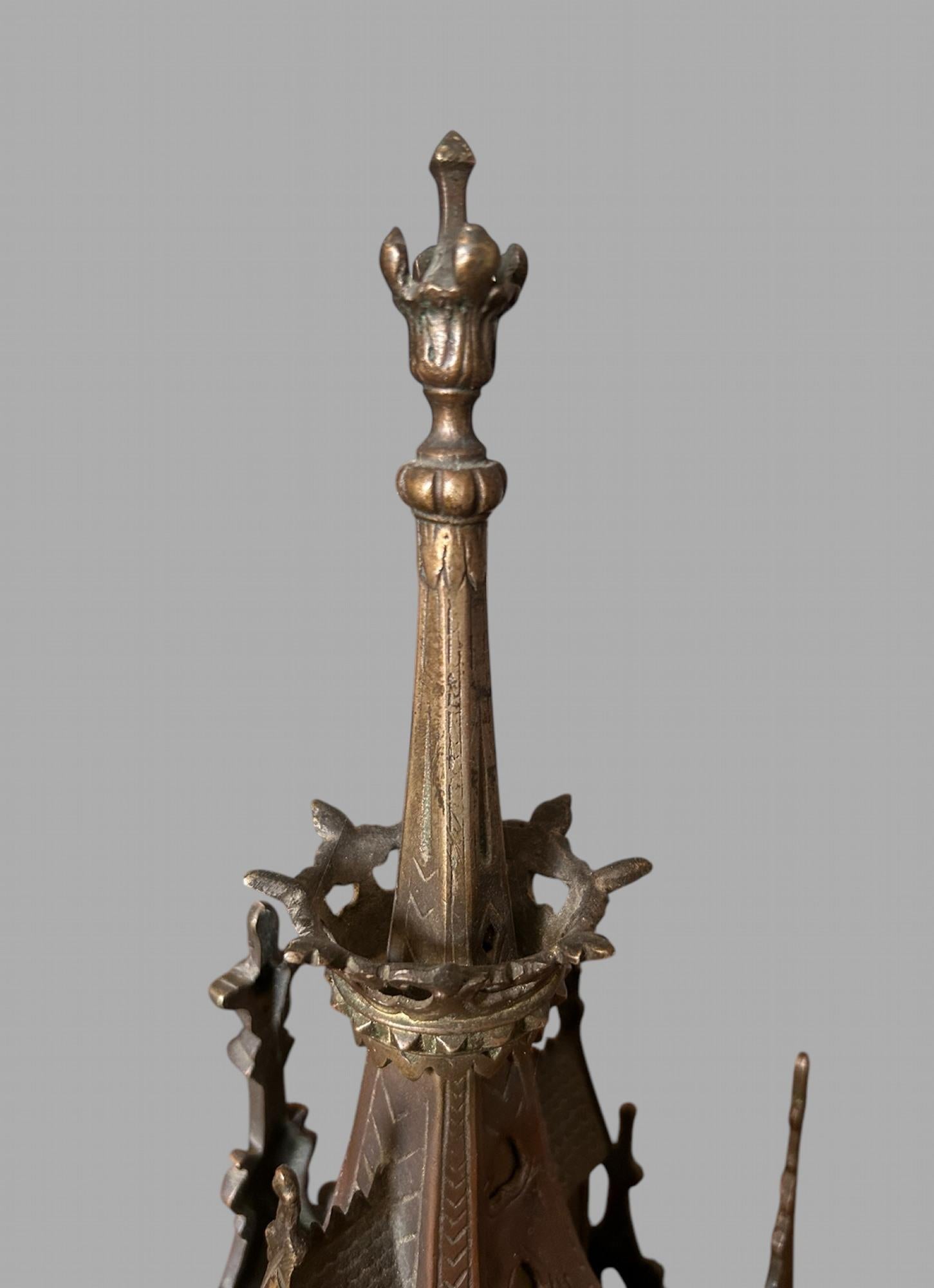 A French 19thc Bronze Gothic Shelf Clock . With an embossed dial and Porcelain numbers that has a 8 day time and strike movement. The piece has a number of decorative details including seven spires not including main spire and porcupine type figure