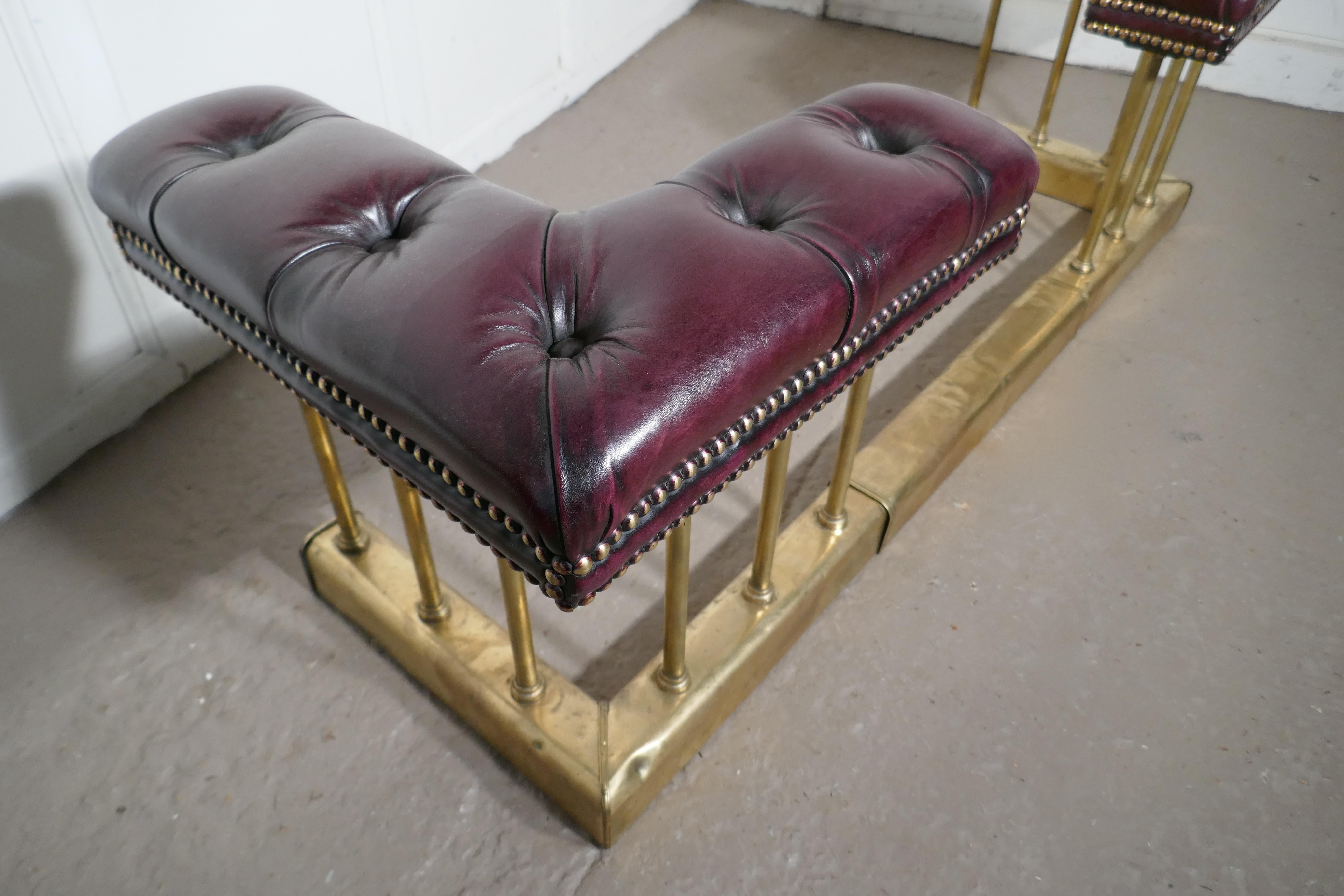A lovely old adjustable brass and leather club fender

This is a lovely piece of country House Furniture, unusually the fender is a adjustable in length it has new deeply buttoned and studded leather seats done in burgundy colored leather
The