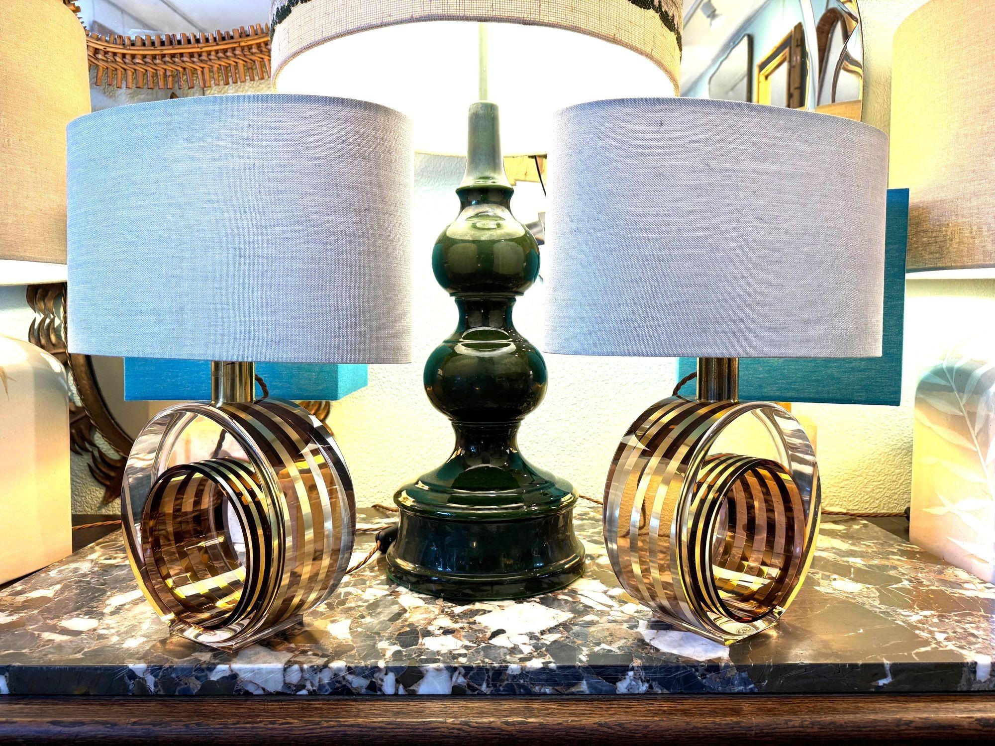 Una bella coppia di lampade italiane in lucite rosa e ottone degli anni '70 di Romeo Rega per l'azienda italiana di illuminazione Castline, con base circolare in lucite. Ogni base è dotata di bande di ottone e di un colore bronzo fumé, il tutto