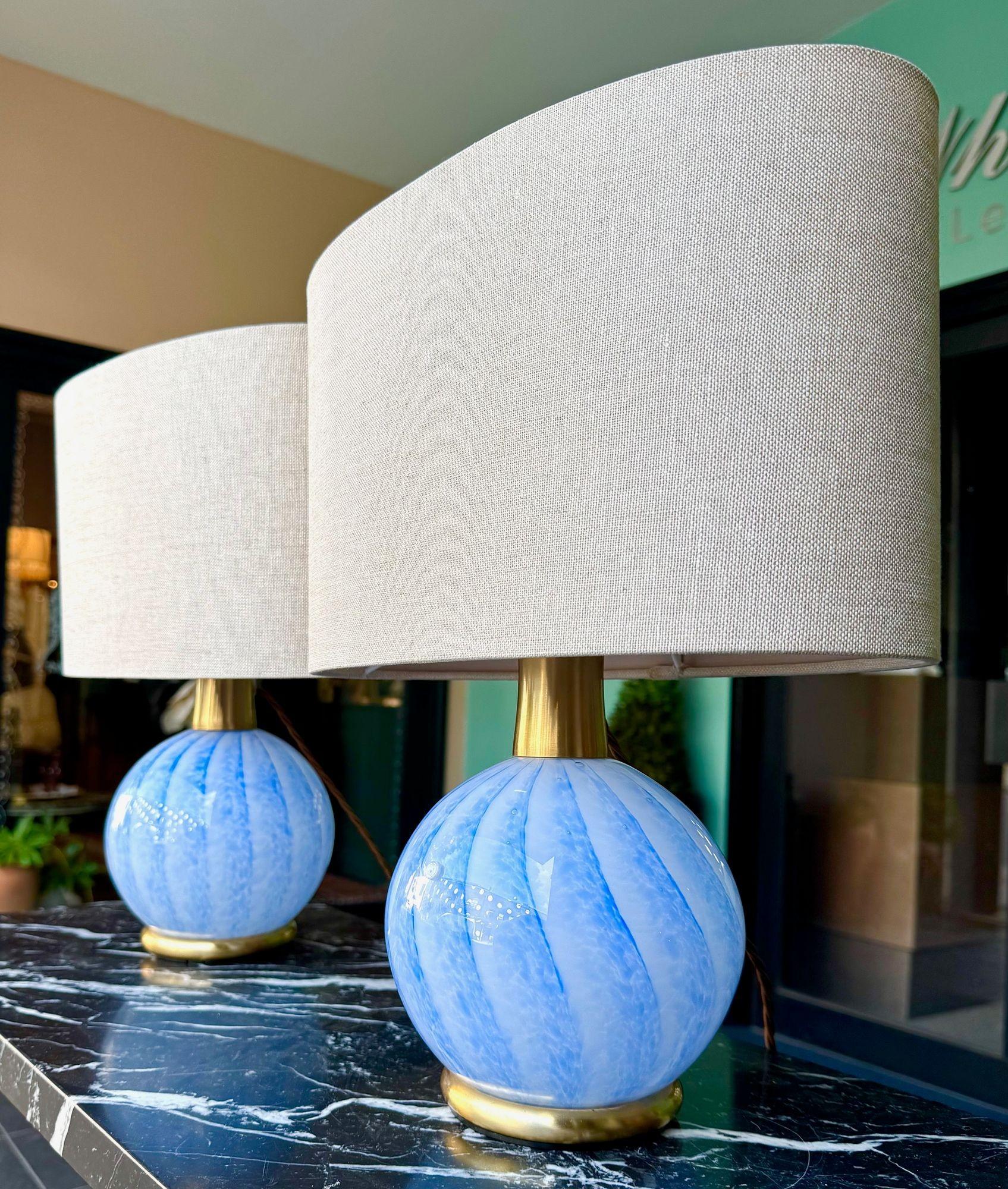 A pair of 1960s blue swirl Murano glass and brass lamps by La Murrina. Each lamp has a handblown blue swirl base mounted on a brass base with brass top fitting and also an internal fitting inside the glass. Each with LM glass initials and inscribed