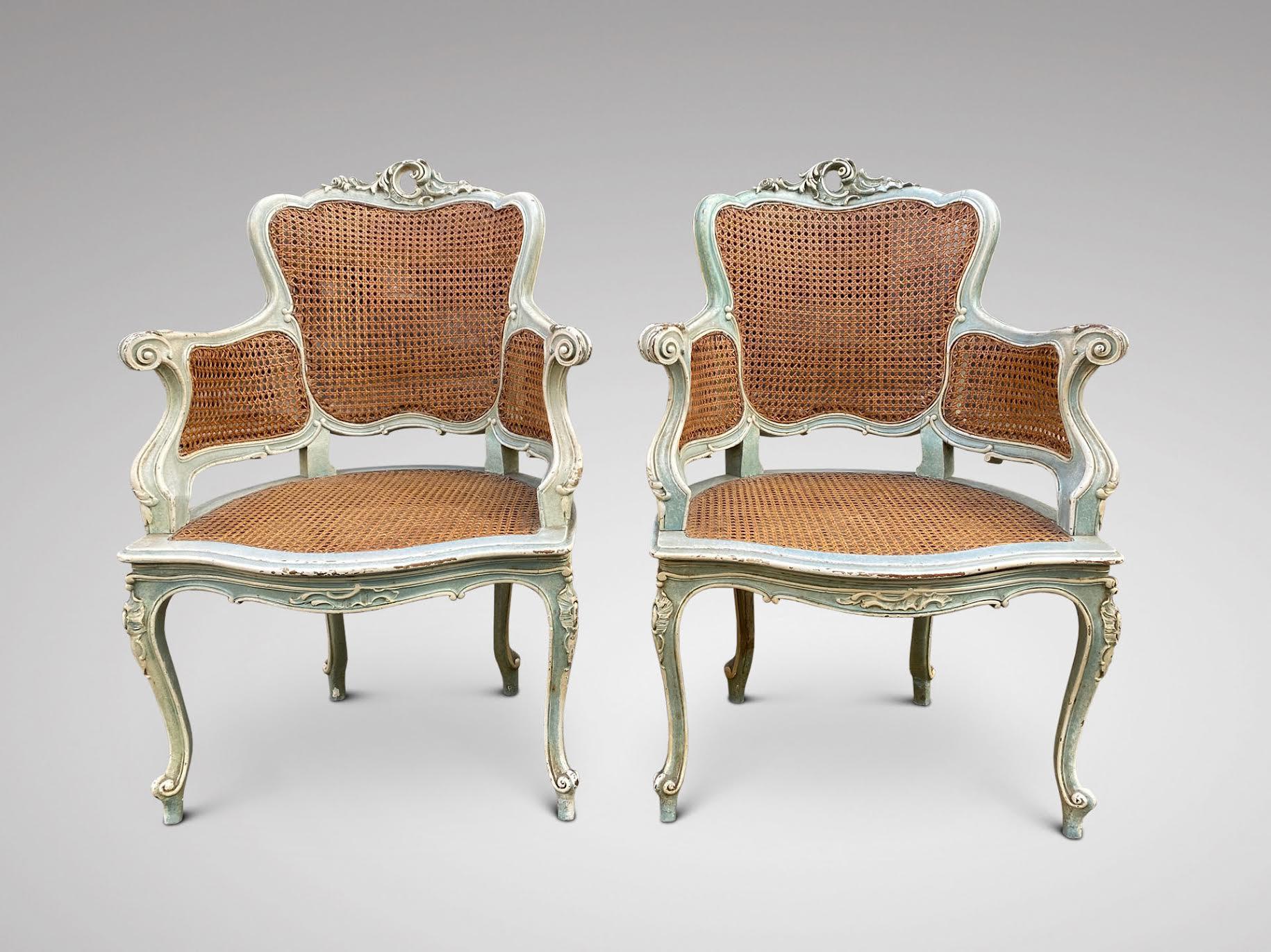 Une paire de fauteuils de qualité en canne sculptée, peints en bleu clair et blanc, datant du 19ème siècle. Finement sculptée à la main et extrêmement confortable, cette paire de fauteuils présente de magnifiques lignes sinueuses typiques de la