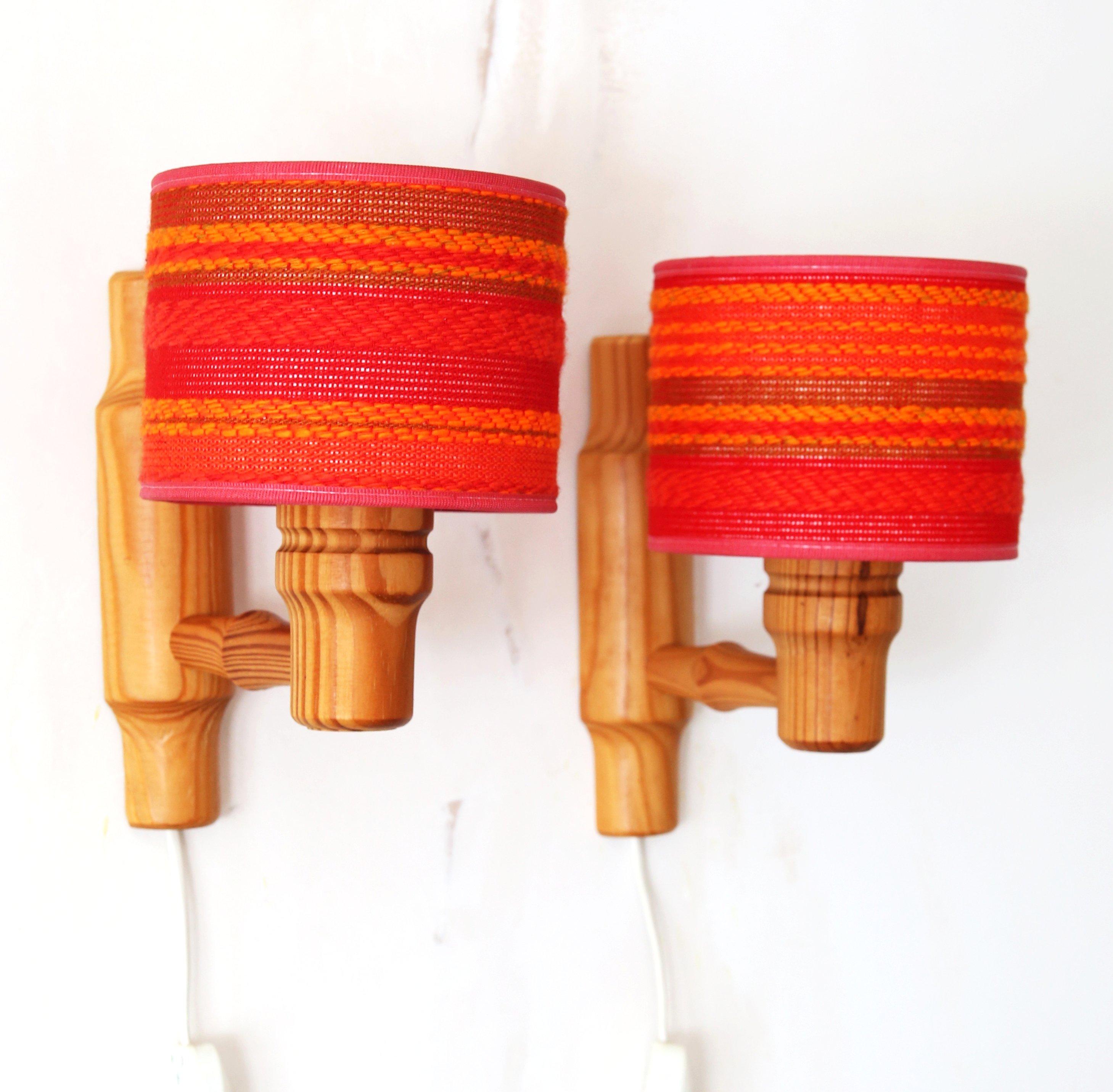 A lovely pair of 70s Danish turned pine wall sconces by Maxam Denmark

The wonderful warmth of the 70s pine fixings contrasts beautifully with the lampshades covered in a heavily woven textured fabric with varying shades of red, orange and pink on