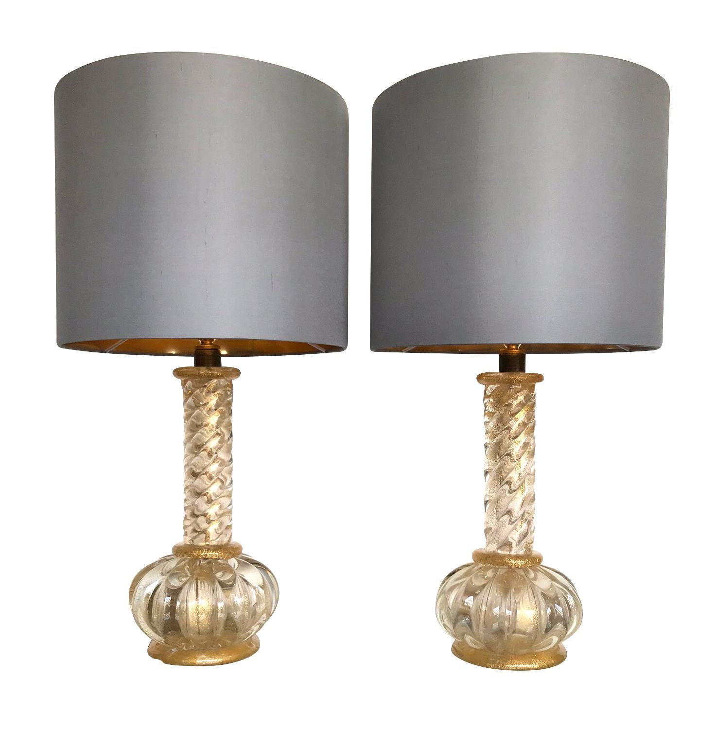 A lovley pair of Barovier and Toso Murano glass lamps with gold leaf in the clear and gold glass, with twisted glass stems and gold collars in the middle and top of the base. With new bespoke slate grey shades with gold linings. Re wired with new