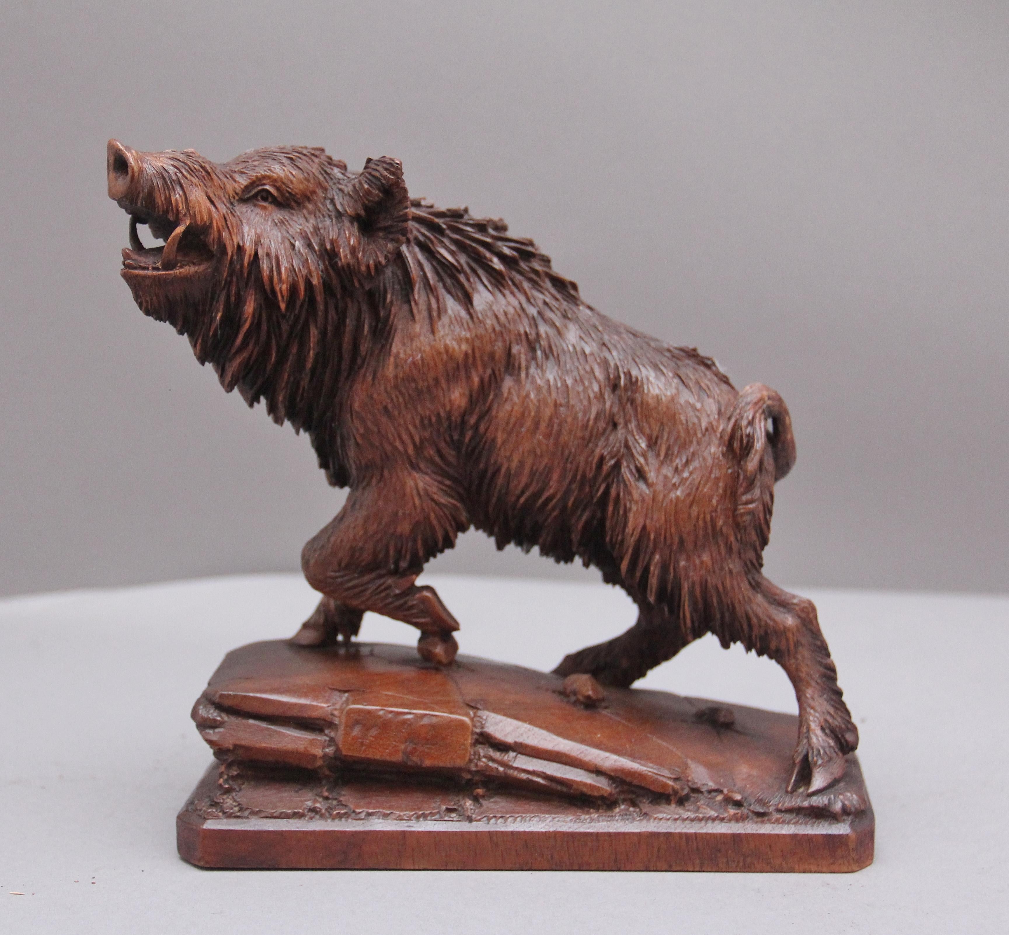 A lovely quality 19th Century black forest carving of a wild boar, with his left leg raised and standing on boulder raised on a platform base. Circa 1880.