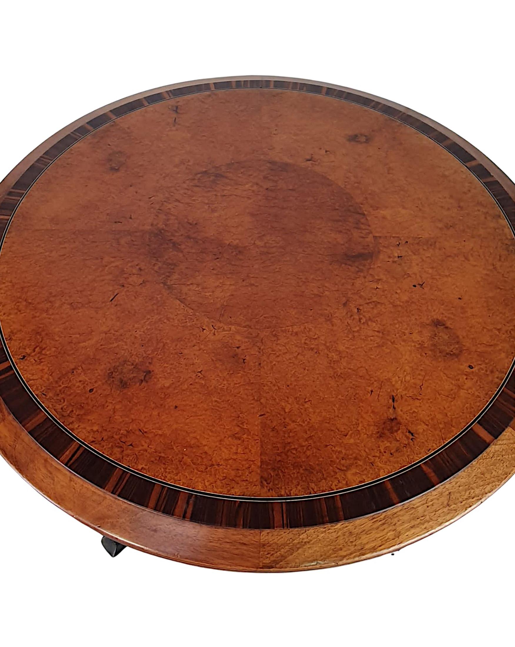 A lovely quality early 20th century amboyna and fruitwood coffee table, cross banded and line inlaid throughout, the moulded top of circular form raised above frieze with brass mounts supported on slender tapering square leg terminating on brass