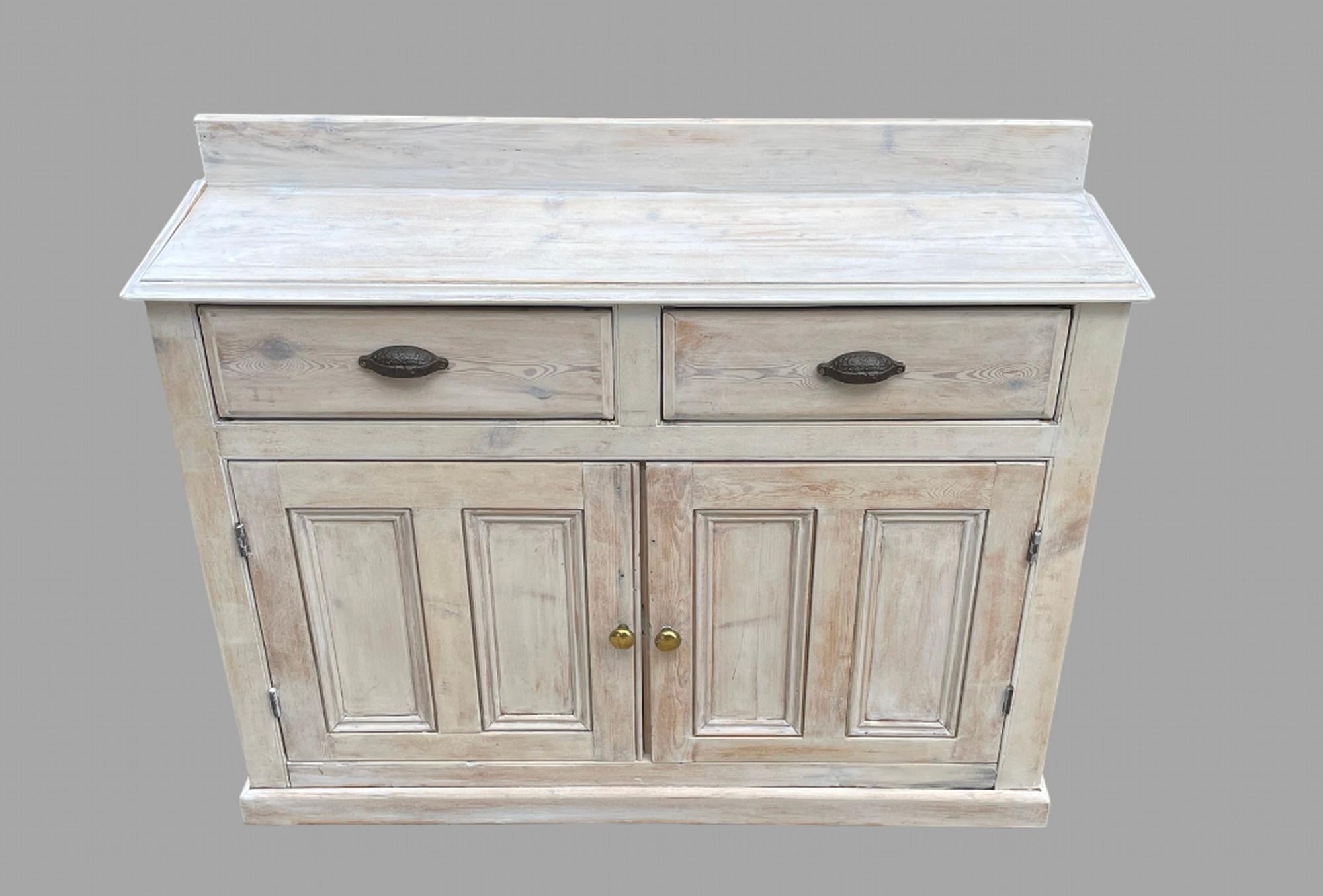 A lovely Rustic Pine Dresser or a sideboard that has been stripped and limed with two drawers and two cupboards and with a shelf.