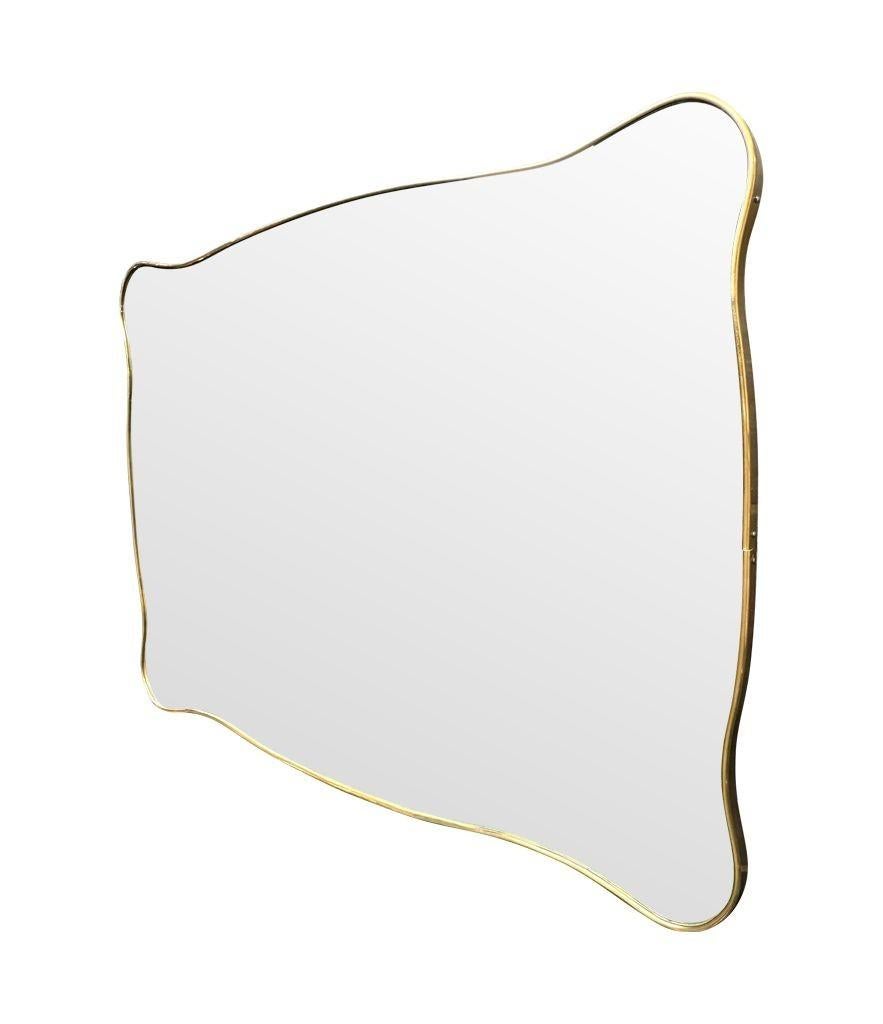 Un delizioso specchio sagomato con cornice in ottone italiano degli anni '50, di forma orizzontale o verticale in vendita 2