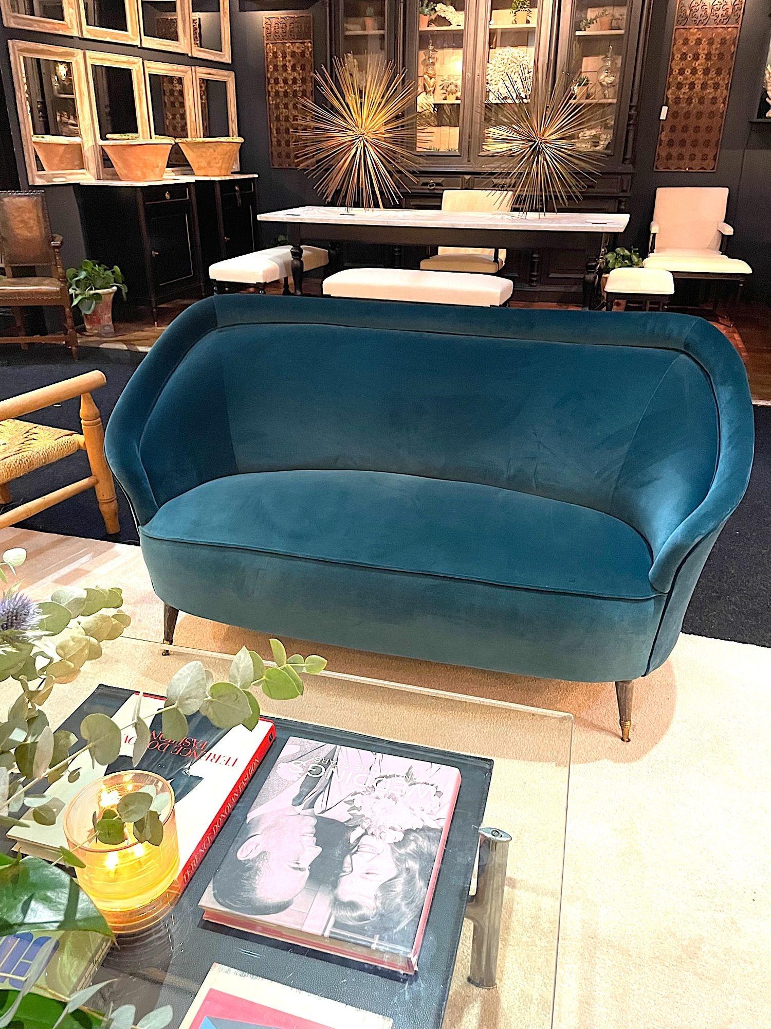 A lovely shaped orignal Italian 1950s two seater sofa with curved back on brass and wood feet. Newly upholstered in Designers Guild “Verese” Kingfisher velvet fabric.