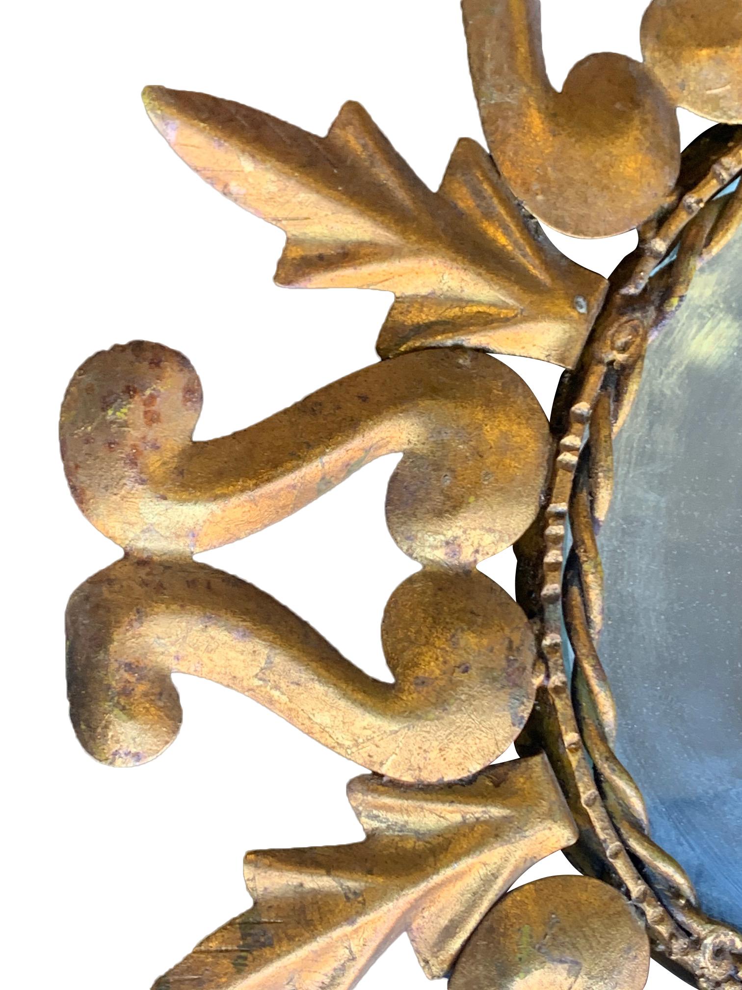 A lovely Spanish ornate gilt metal oval sunburst wall mirror with original plate with gilt metal rope inside detail.