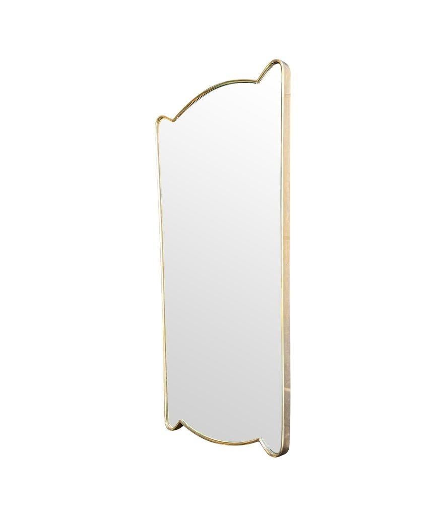 A lovely unique shaped orignal 1950s Italian shield mirror with thick brass frame, solid wood back and original plate