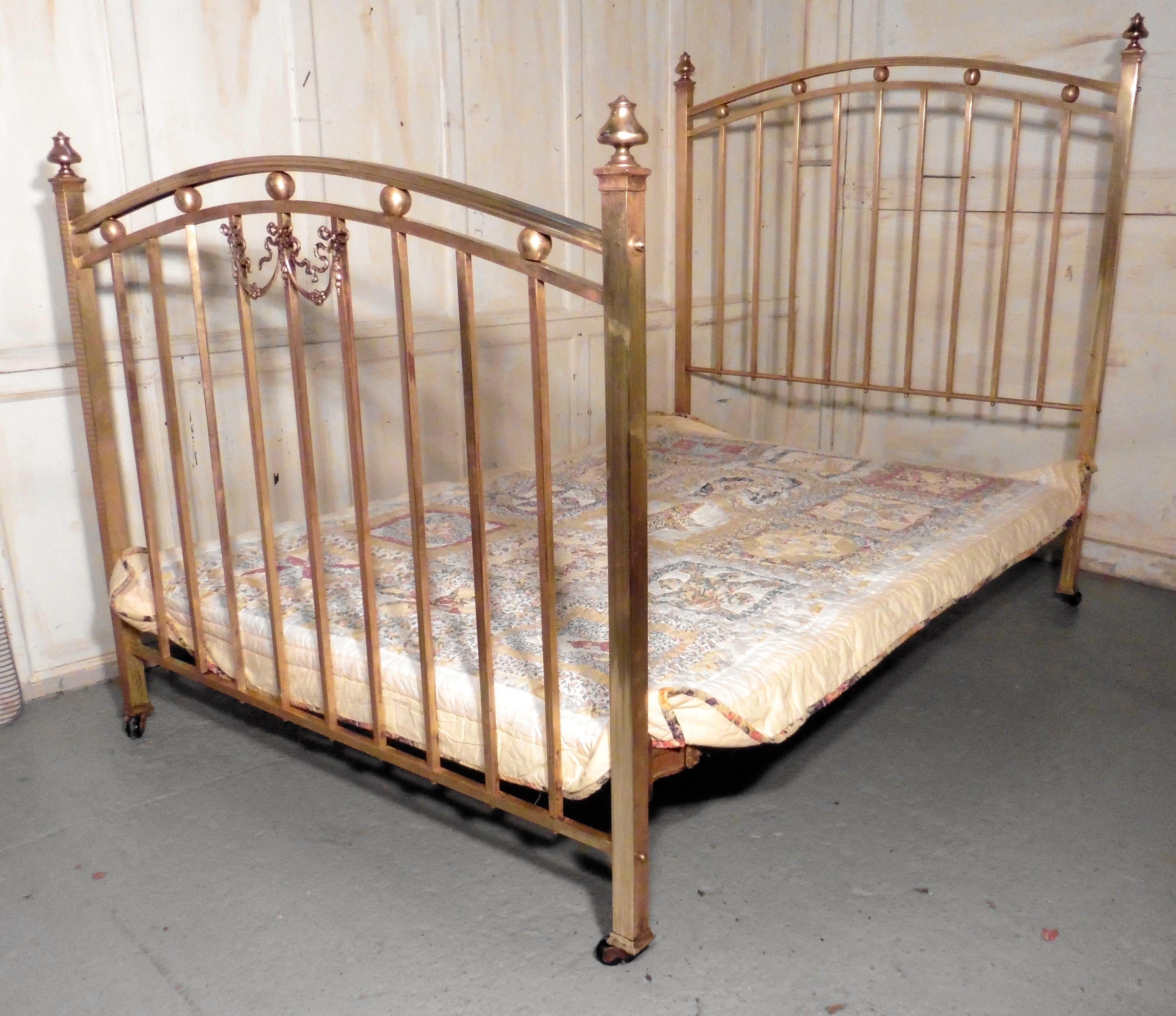 A lovely Victorian brass double bed

The bed dates from circa 1880, both head and foot board are high with a curved top rail, it is decorated with brass balls and rails with turned bed knobs at each end, there is a also a ribbon and swag