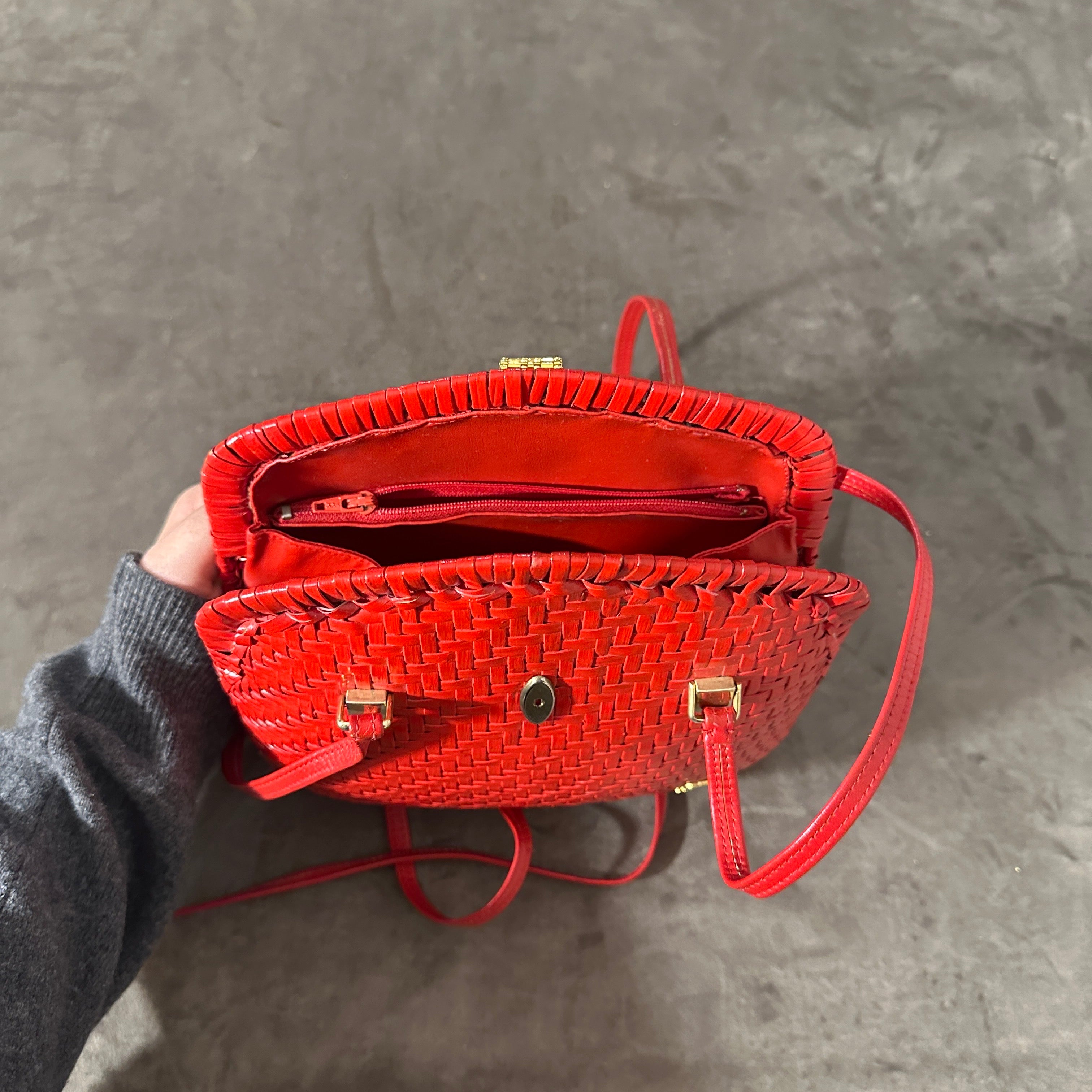 This stunning vintage high quality handbag from the 1960s features a striking woven wicker design in a vibrant, bold red. The structured, dome-shaped silhouette showcases a compact yet stylish form, ideal for both casual and elegant occasions. The