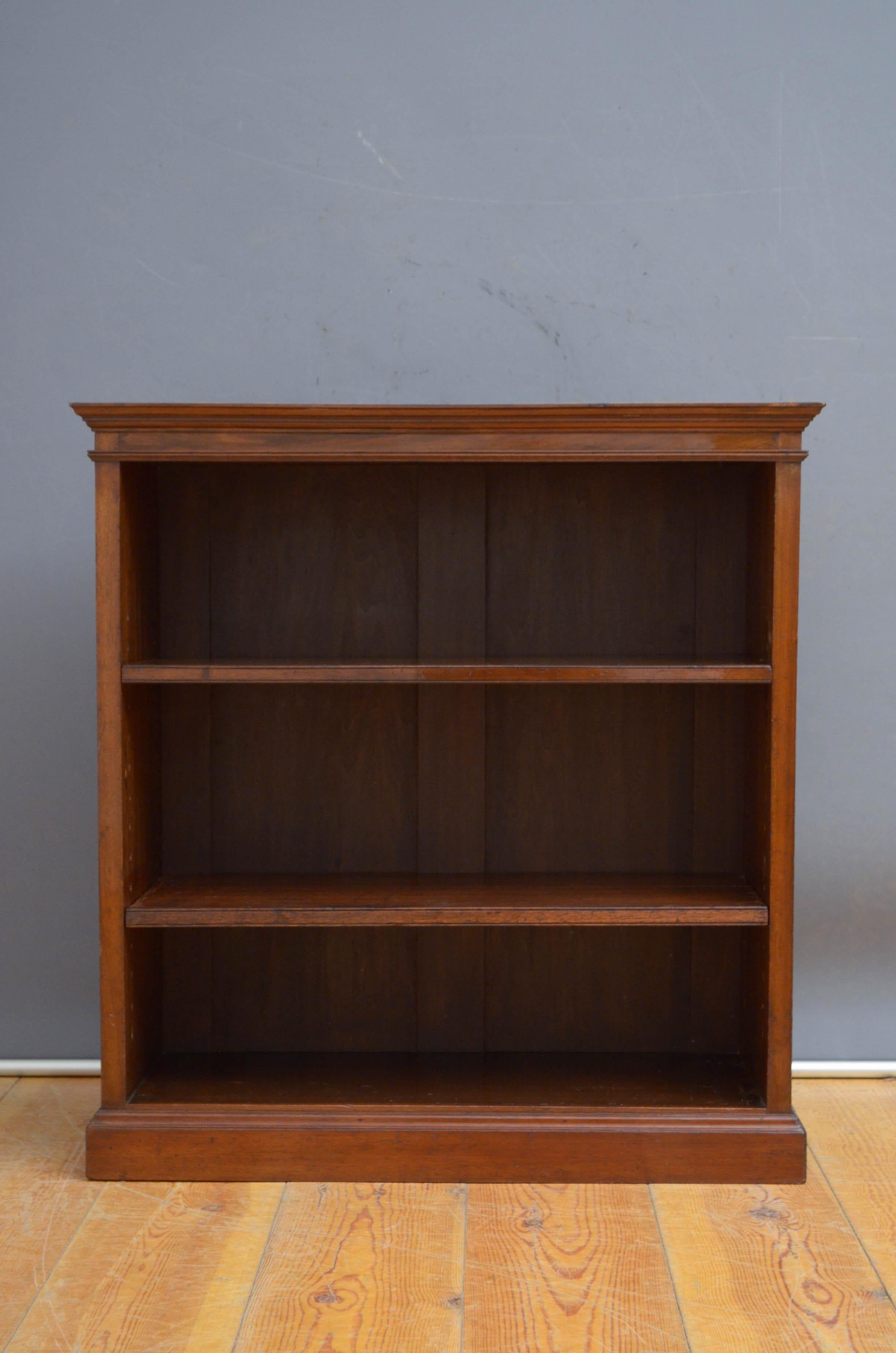 Sn5512 Edwardian mahogany and inlaid open bookcase of unusually narrow proportions, having figured mahogany top crossbanded in satinwood above shallow frieze and two height adjustable shelves, all standing on plinth base. This antique bookcase is in