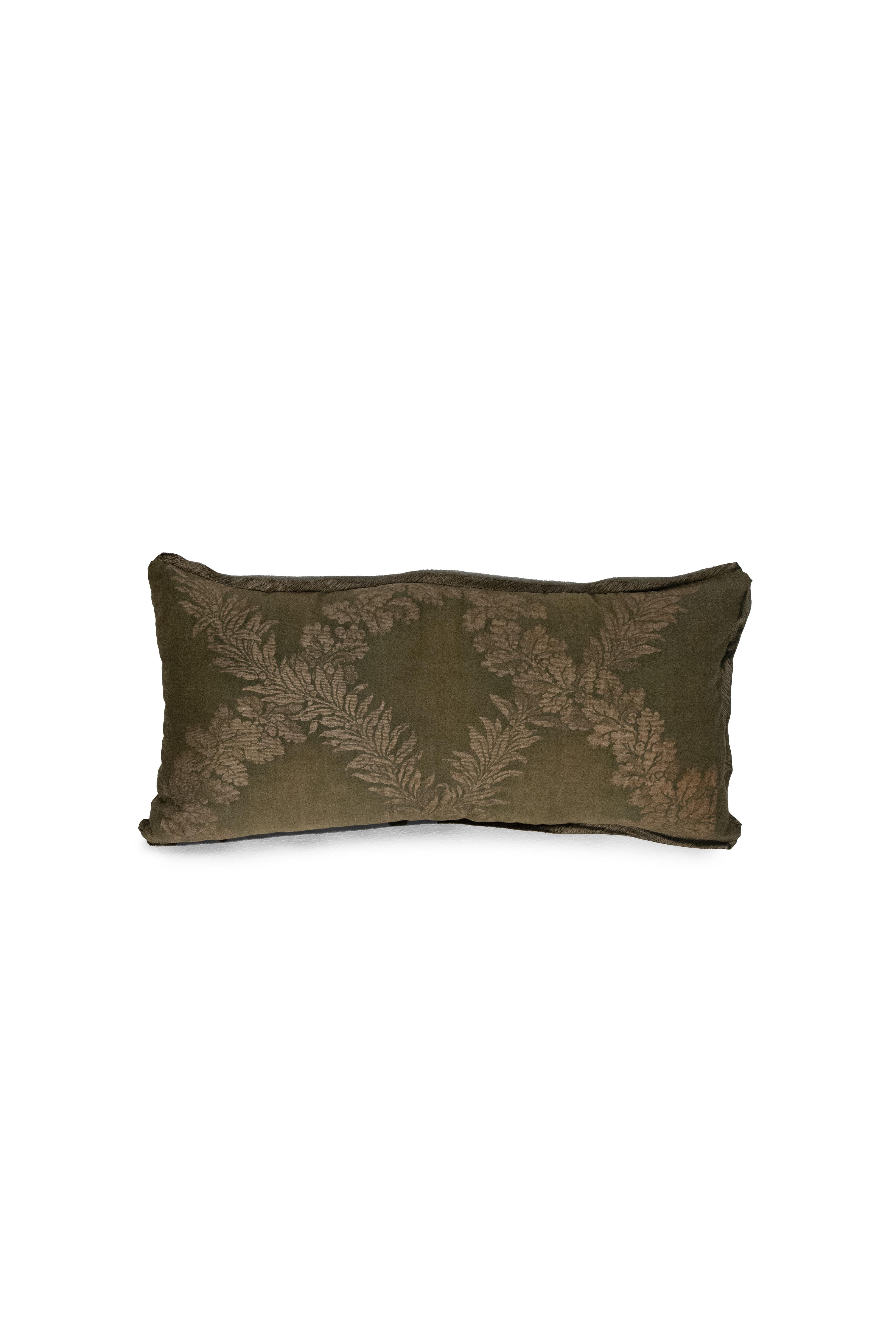 Ce coussin lombaire est composé d'un tissu Fortuny au motif Crosoni, dont le fond est vert et qui est rehaussé d'un biais de soie. Le support est en taffetas de soie dorée. Le design s'inspire d'un style Empire français du XVIIIe siècle avec un