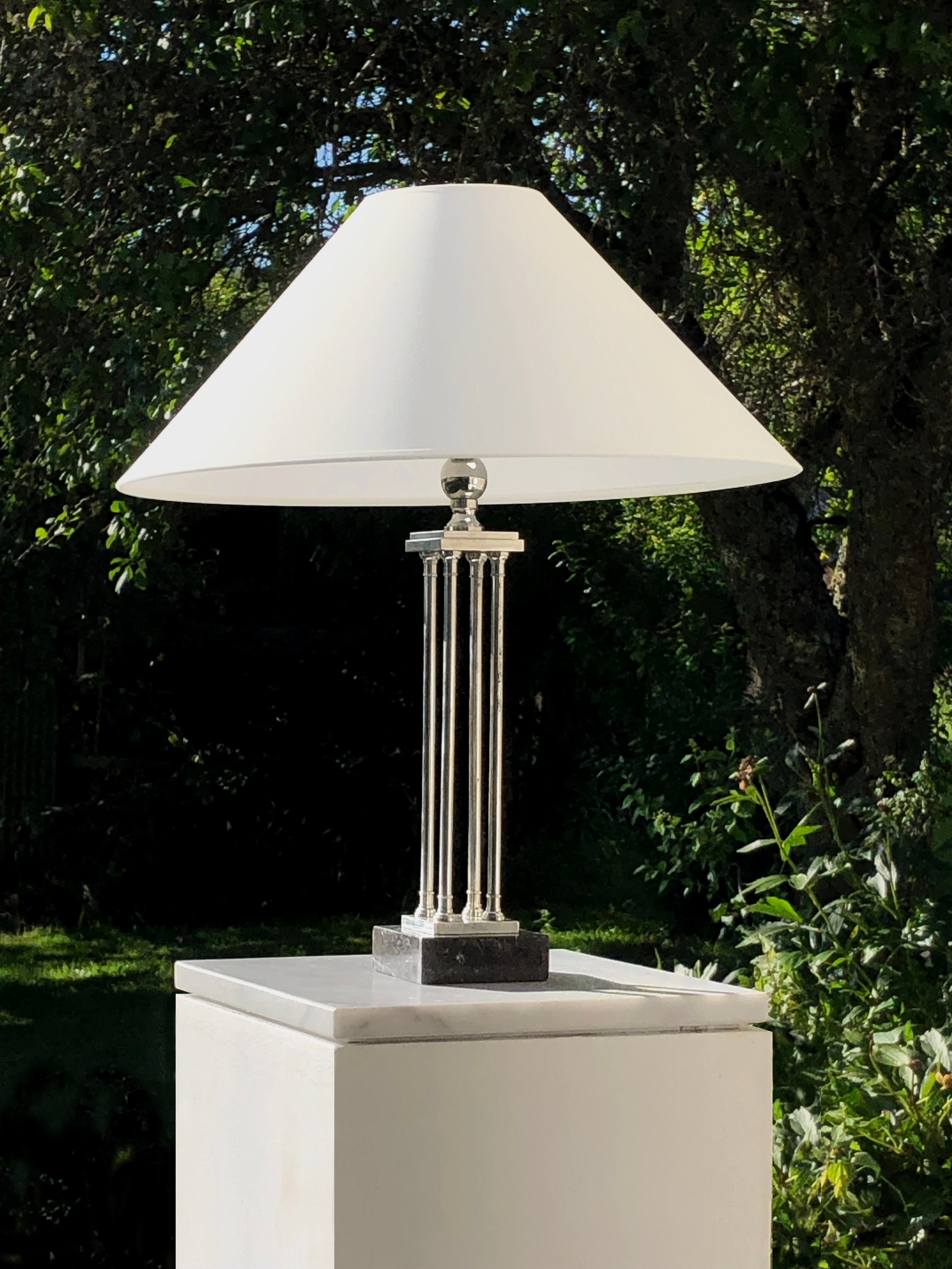 A luxurious and rigorous table lamp, Art-Deco, Modernist, Constructivist, Bauhaus, geometric structure mounted on a square black marble base, 4 high legs forming 4 columns supporting a square tiered top topped with a spherical ball in nickel-plated