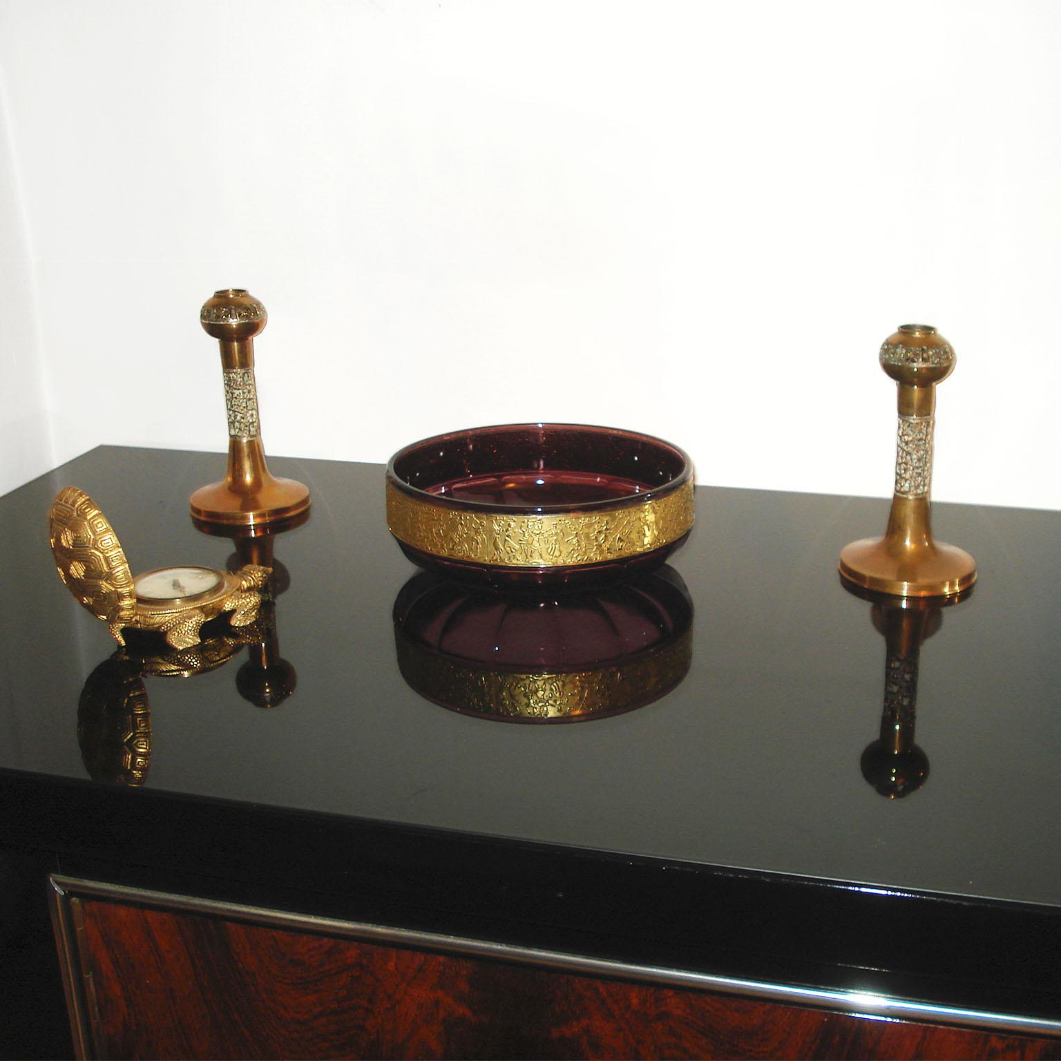 Lussuosa ciotola in cristallo Art Nouveau con ametista e fascia in oro di Moser.
Una bellissima coppa da centrotavola in cristallo soffiato a mano di colore viola intenso con un'ampia fascia intorno al corpo, decorata con una scena tagliata a cammeo