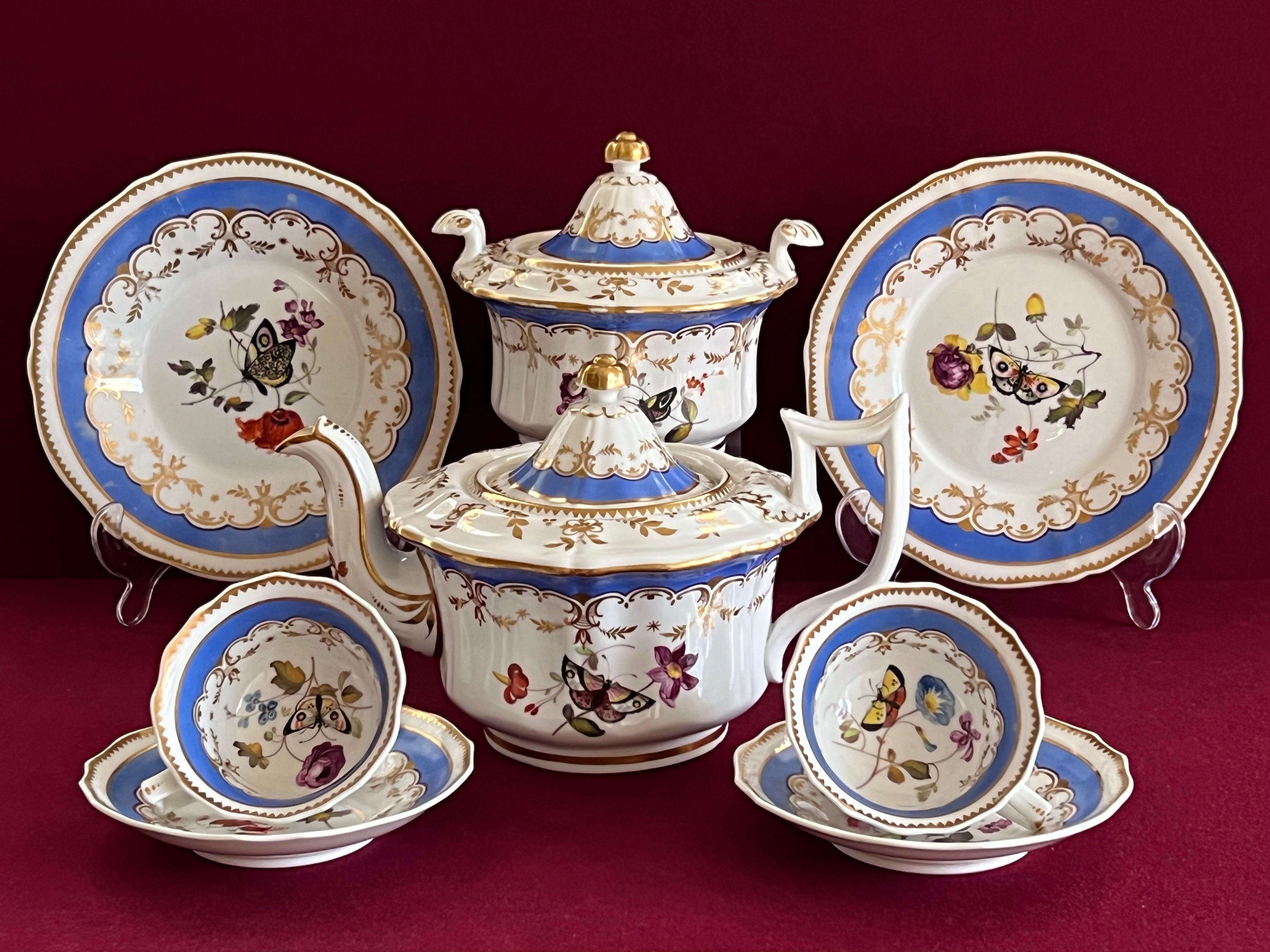 A Machin Porcelain Part Tea Set in pattern 955 circa 1835. Finely decorated with a matte blue border, each piece being decorated with a finely painted Butterfly.

Consisting of a teapot, a sugar box, 2 tea cups and saucers and 2 plates.