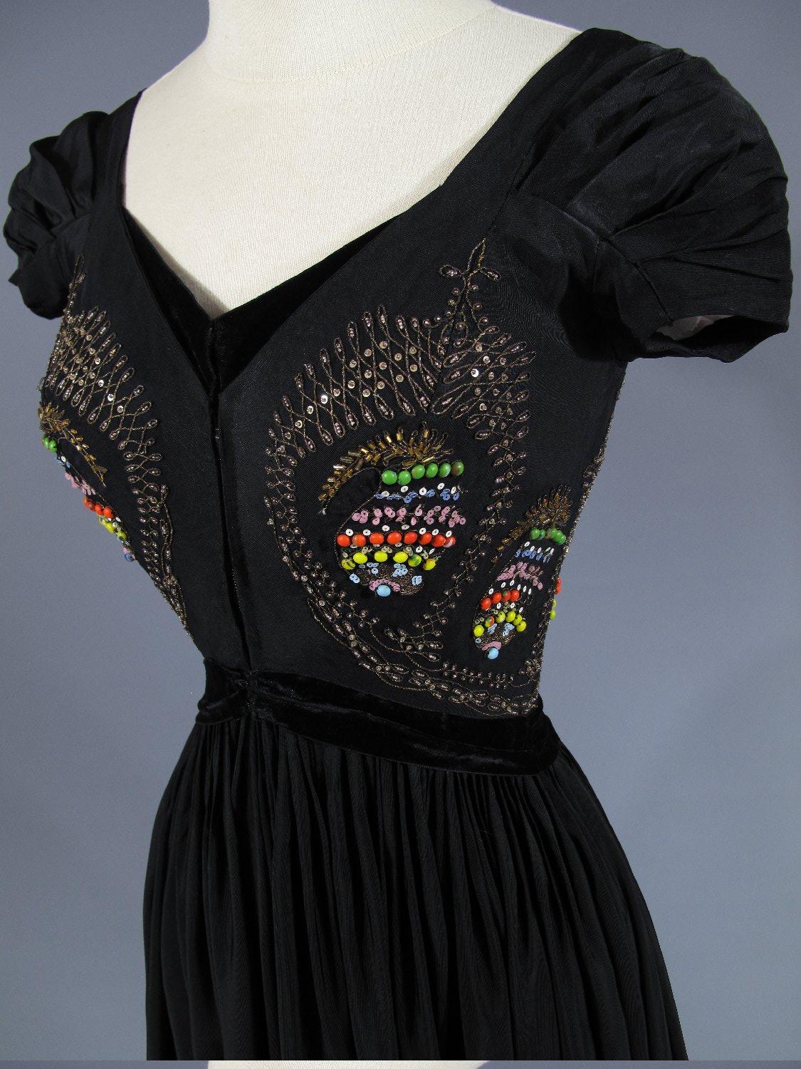 Circa 1953

France

Grand Soir dress in black silk faille by Madame Grès Haute Couture, 1953 collection (similar dress, cover of 
