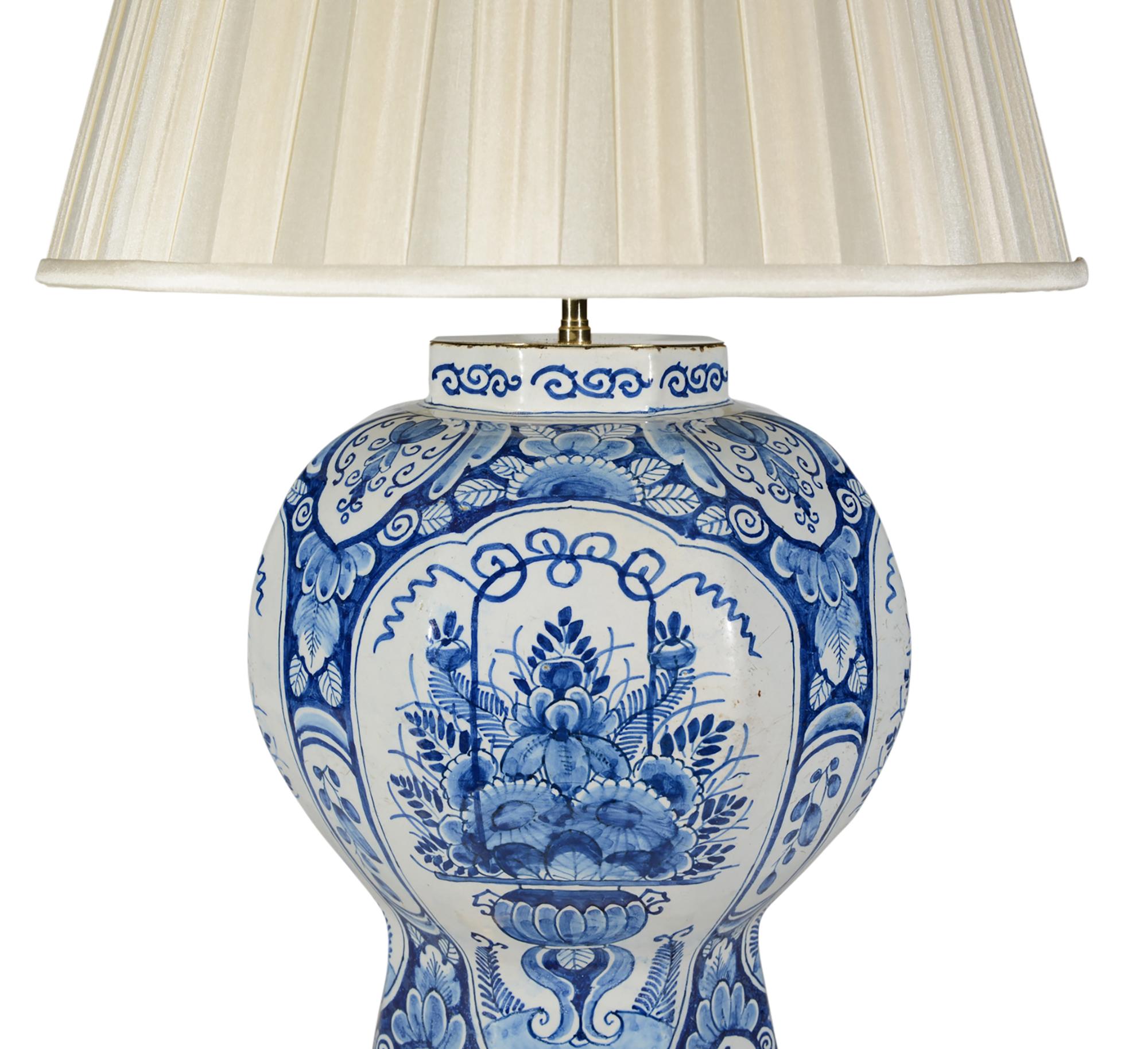 Magnifique grand vase balustre Delft bleu et blanc du XVIIIe siècle, dont le panneau central représente une superbe urne de fleurs et de feuillage. Ce vase est maintenant monté comme une lampe avec une base ajustée dorée à la main. 

Hauteur du vase