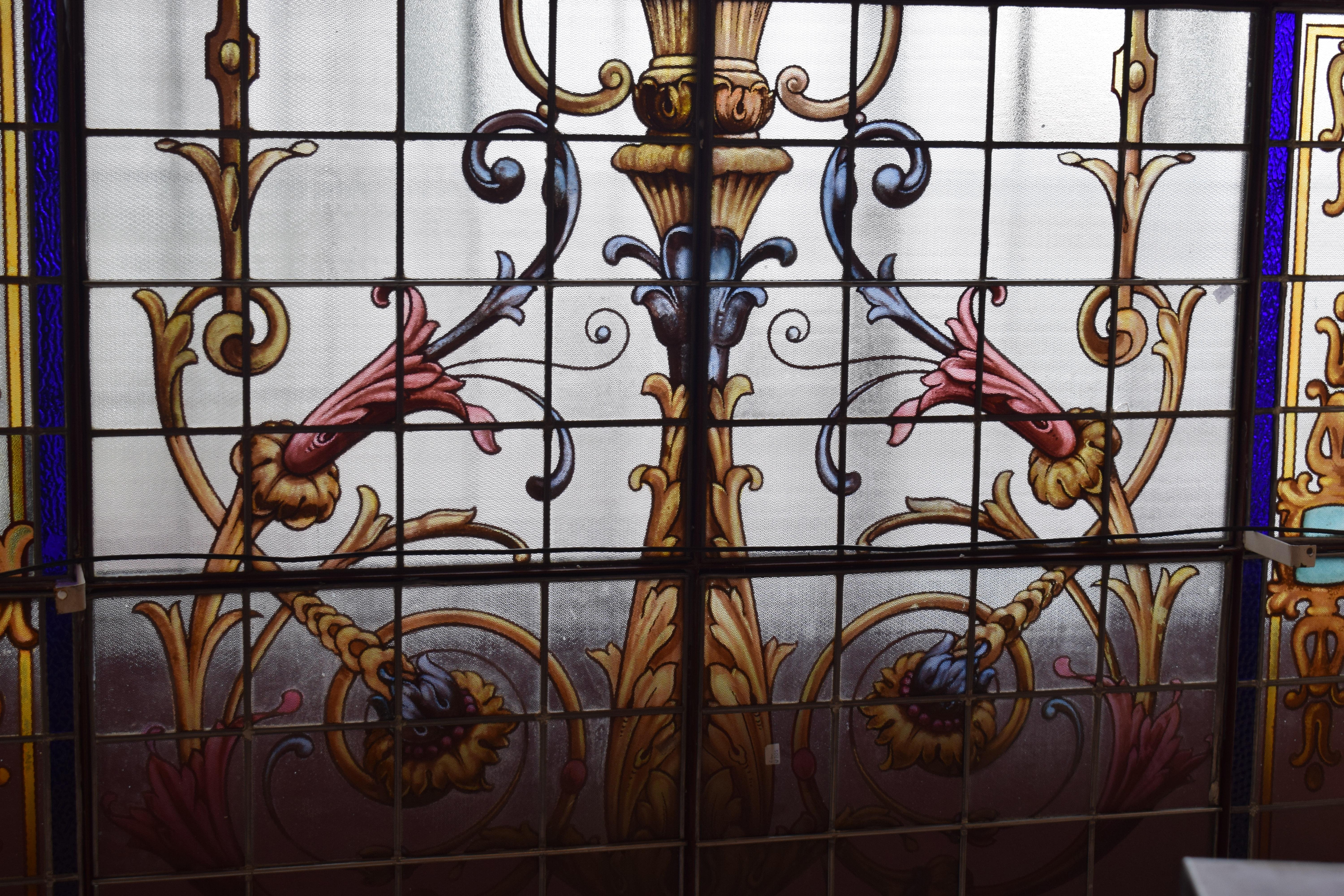 A magnificent late 19th century French Leaded Glass Vitraux Window, depicting flower garlands, flower vase and stylized filigree. 22 panels, all panels recently re-leaded, therefore they are strong and rigid. Iron Frame recently painted, in good