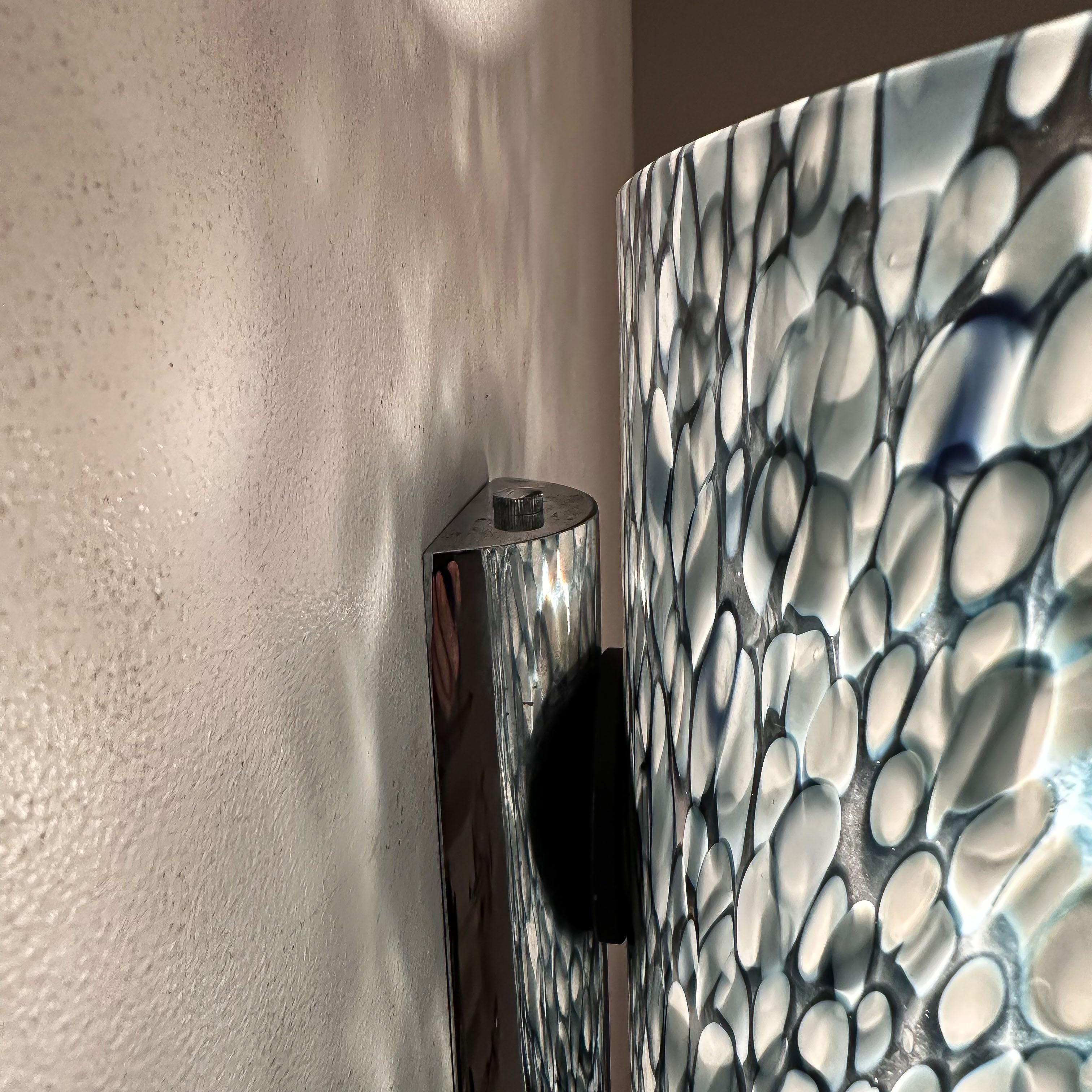 
The Magnificent Neverrino wall lamp by Gae Aulenti for Vistosi, crafted in Murano during the 1970s, is an extraordinary piece that epitomizes the fusion of innovative design and masterful craftsmanship. Gae Aulenti, an iconic Italian architect and