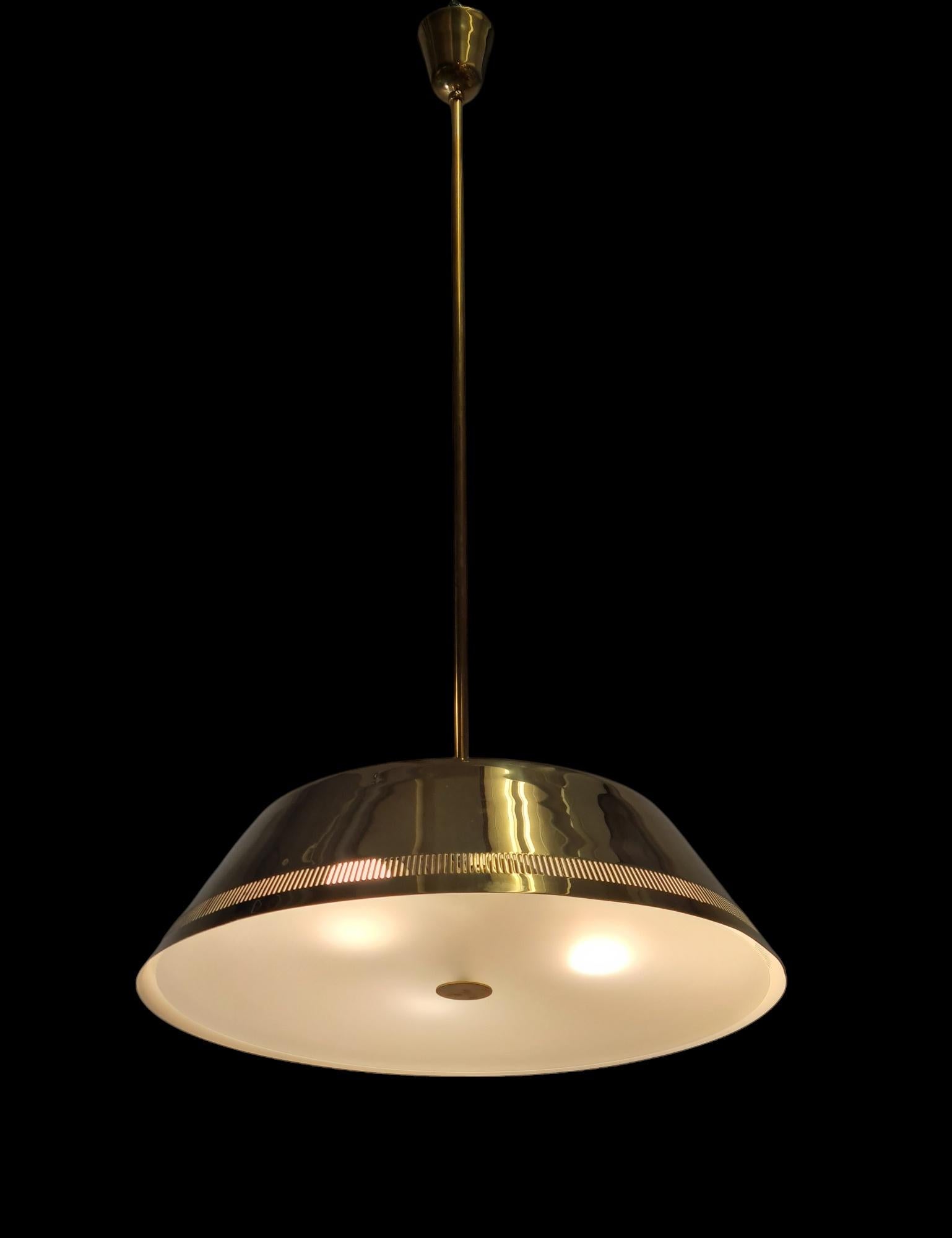 A beautiful and quite a sizeable Paavo Tynell ceiling pendant model no. 82500 for Idman from the 1950s. Because of its size, the lamp suits large rooms, living rooms and other spacious places. The lamp is quite simple and minimalistic in design.