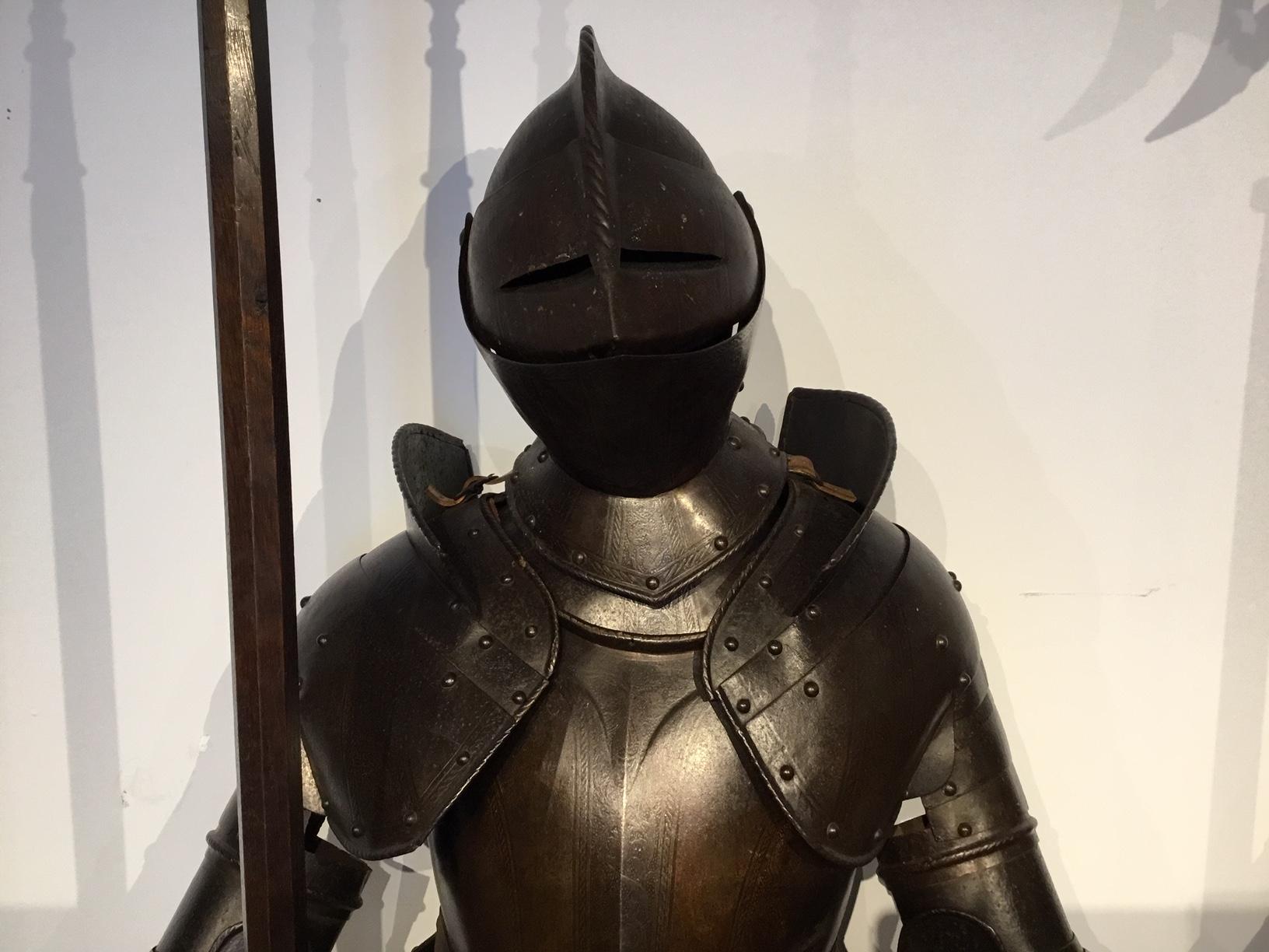 A magnificent pair of 19th century suit of armour in the 16th century style. The well patinated steel finely engraved and showing signs of original gilding. Standing life size complete with leather strapping and chain mail detail, standing upon the
