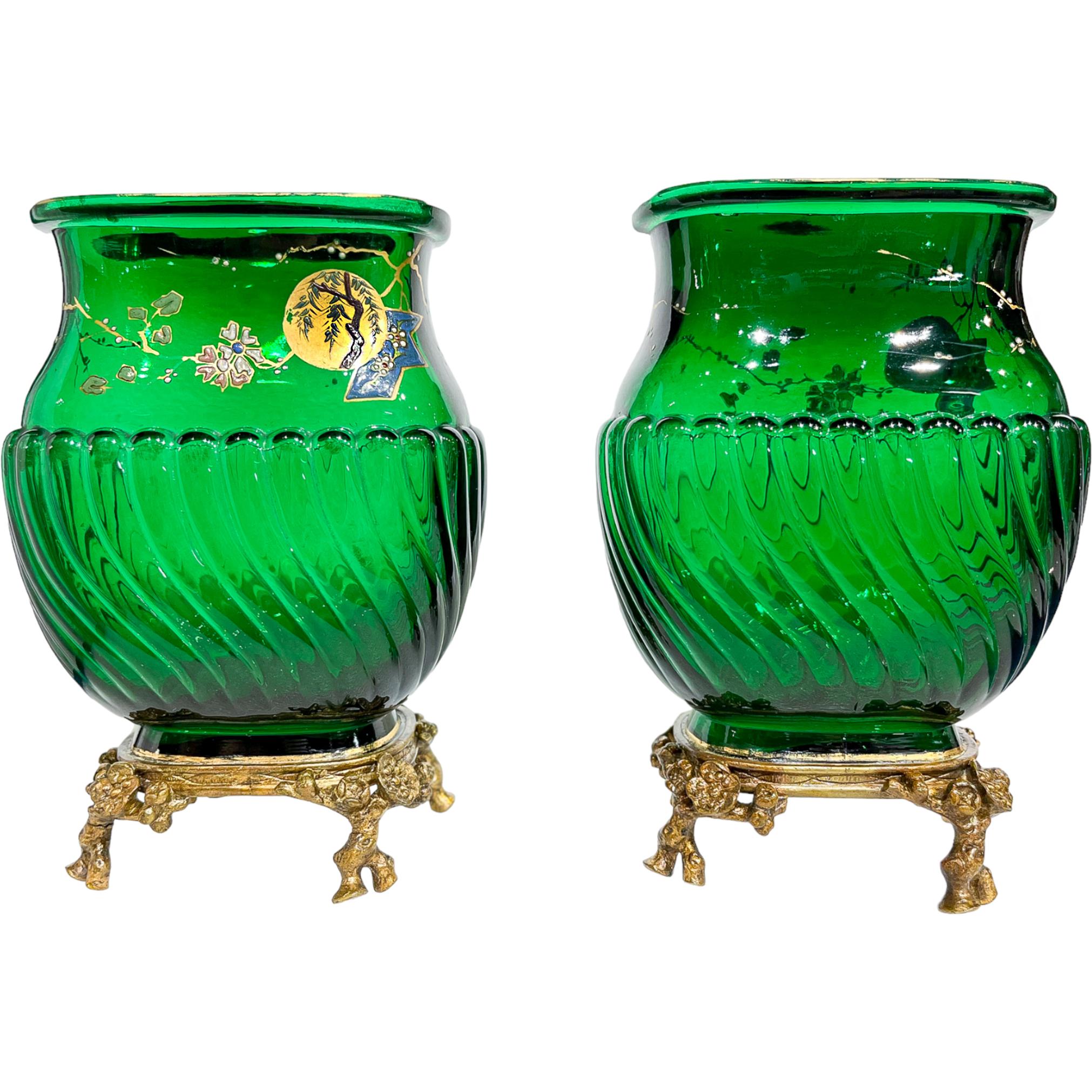 The bright translucent green glass vases with the spiral-fluted bellies. Enameled necks are embellished with a gilded image of the sun behind a blooming sakura tree in Japanese style , with a gilded band around the lip. Surmounted on gilt bronze