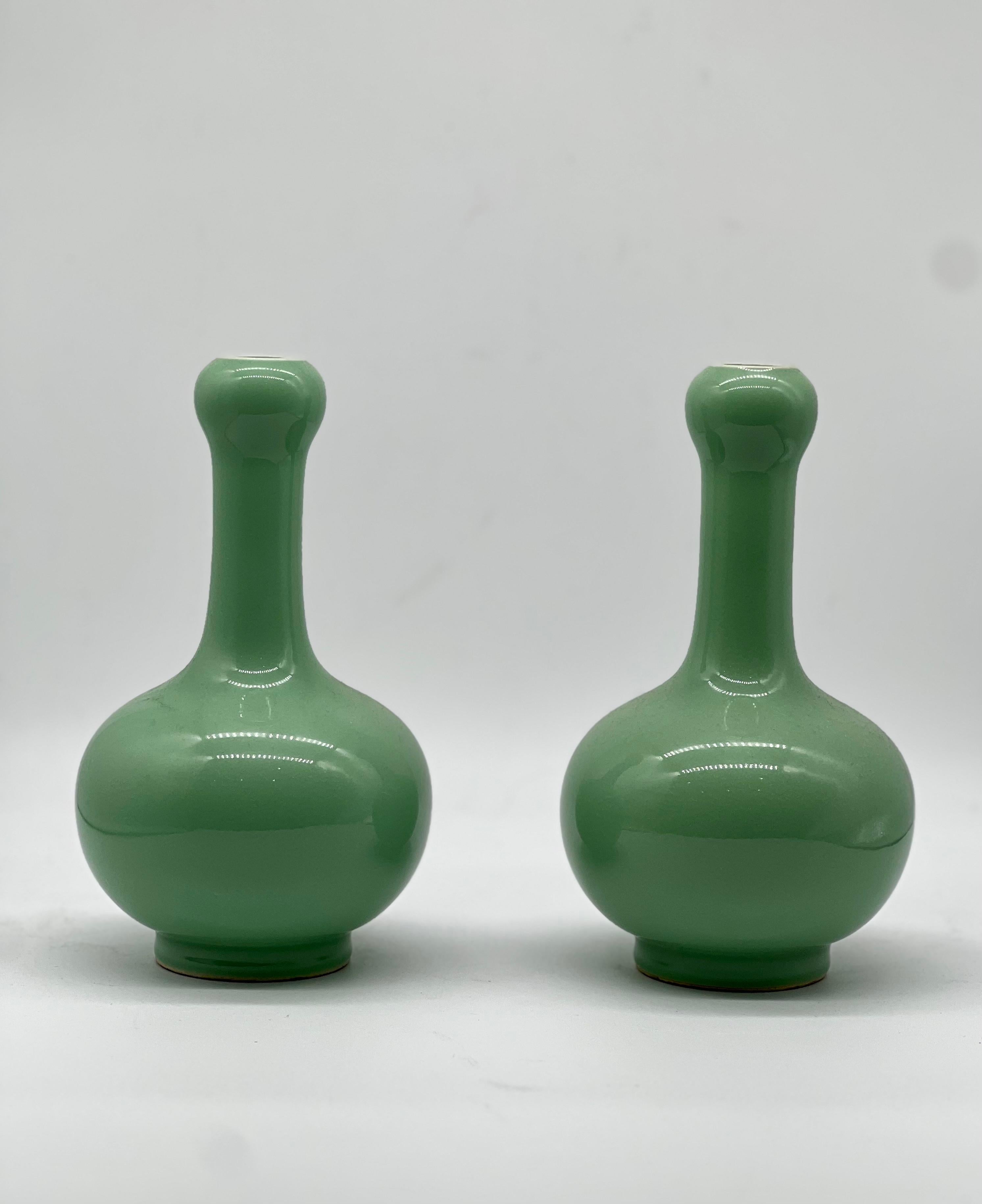 A fine pair of Chinese monochrome apple green glazed vases 
20th C.
in garlic bottle shape , bulbous lower belly, cylindrical neck, enlarge onion head shape, raised on short ring foot.
All reserved hand painted and masterfully covered in an even