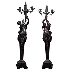 A magnificent pair of free standing female figurative patinated bronze torchère 