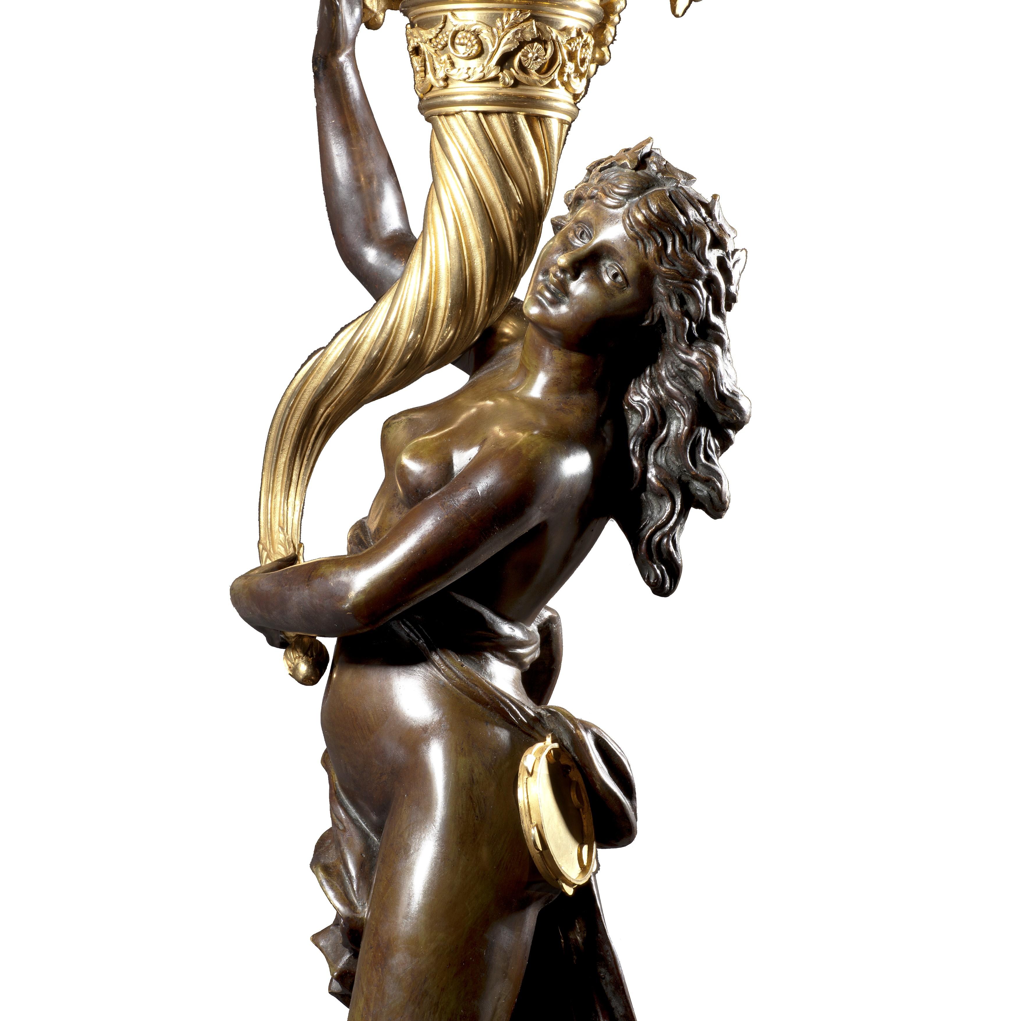 Une magnifique paire de candélabres Louis XVI après clodion

Ces impressionnants candélabres à huit lumières en bronze doré et patiné reposent sur des piédestaux en marbre griotte rouge montés en bronze doré. Chacune est modelée avec une figure