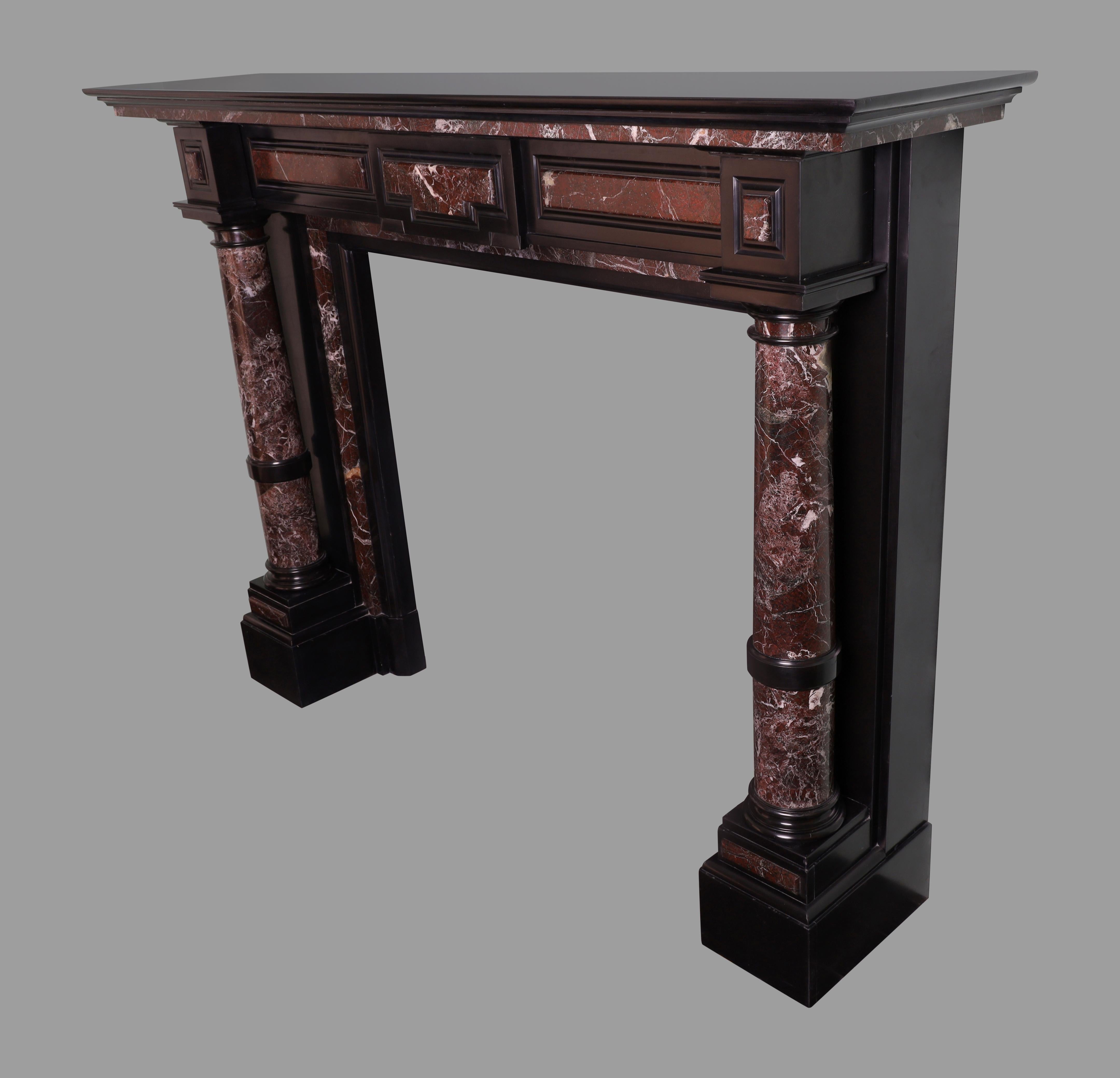 A magnificent polished Belgium Black and Rosso Levanto marble chimneypiece in the Renaissance manner. The moulded shelf set over a panelled frieze, supported by columns in Rosso Levanto with Belgium Black collar detail and large plinth blocks.