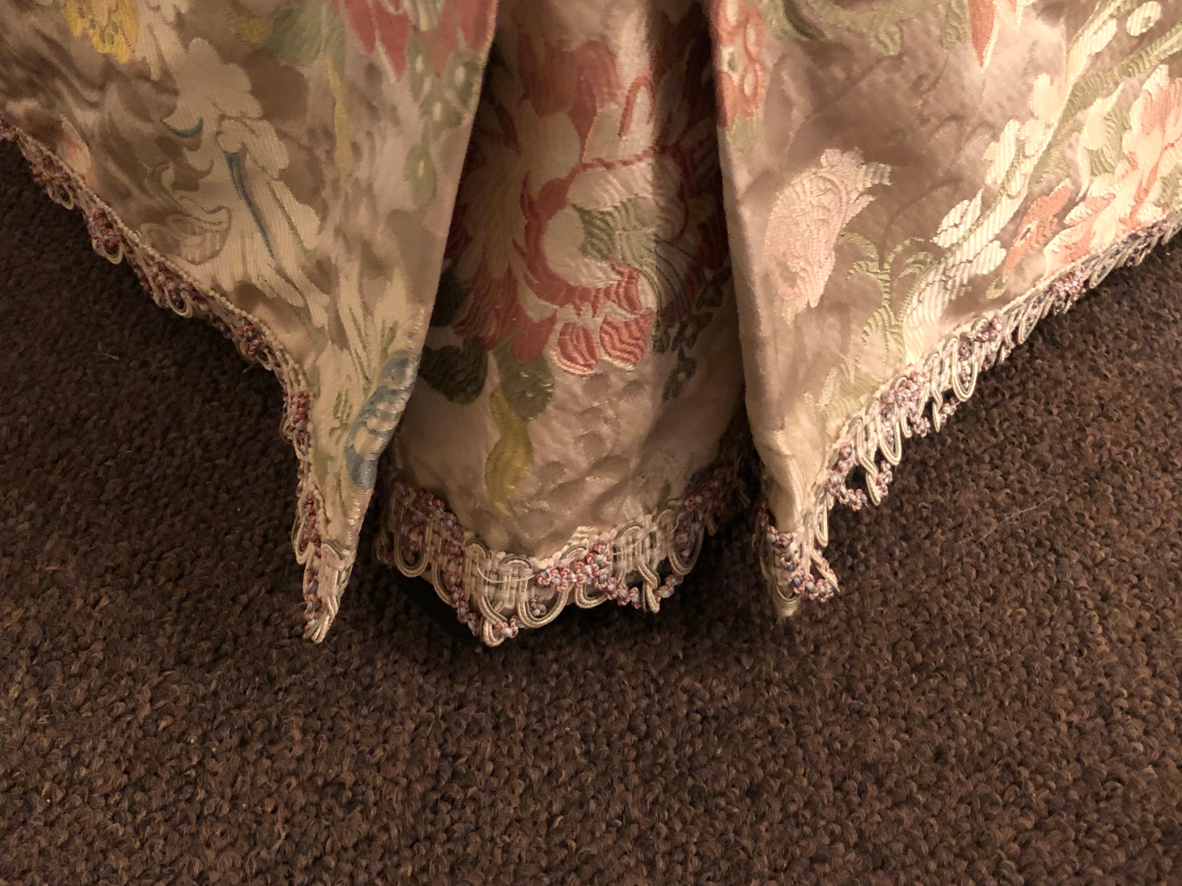A magnificently upholstered overstuffed armchair on casters by O Henry House in the finest silk upholstery that is fully lined and pleated sitting on English style legs with casters. This large and impressive chair is certain to have people talking