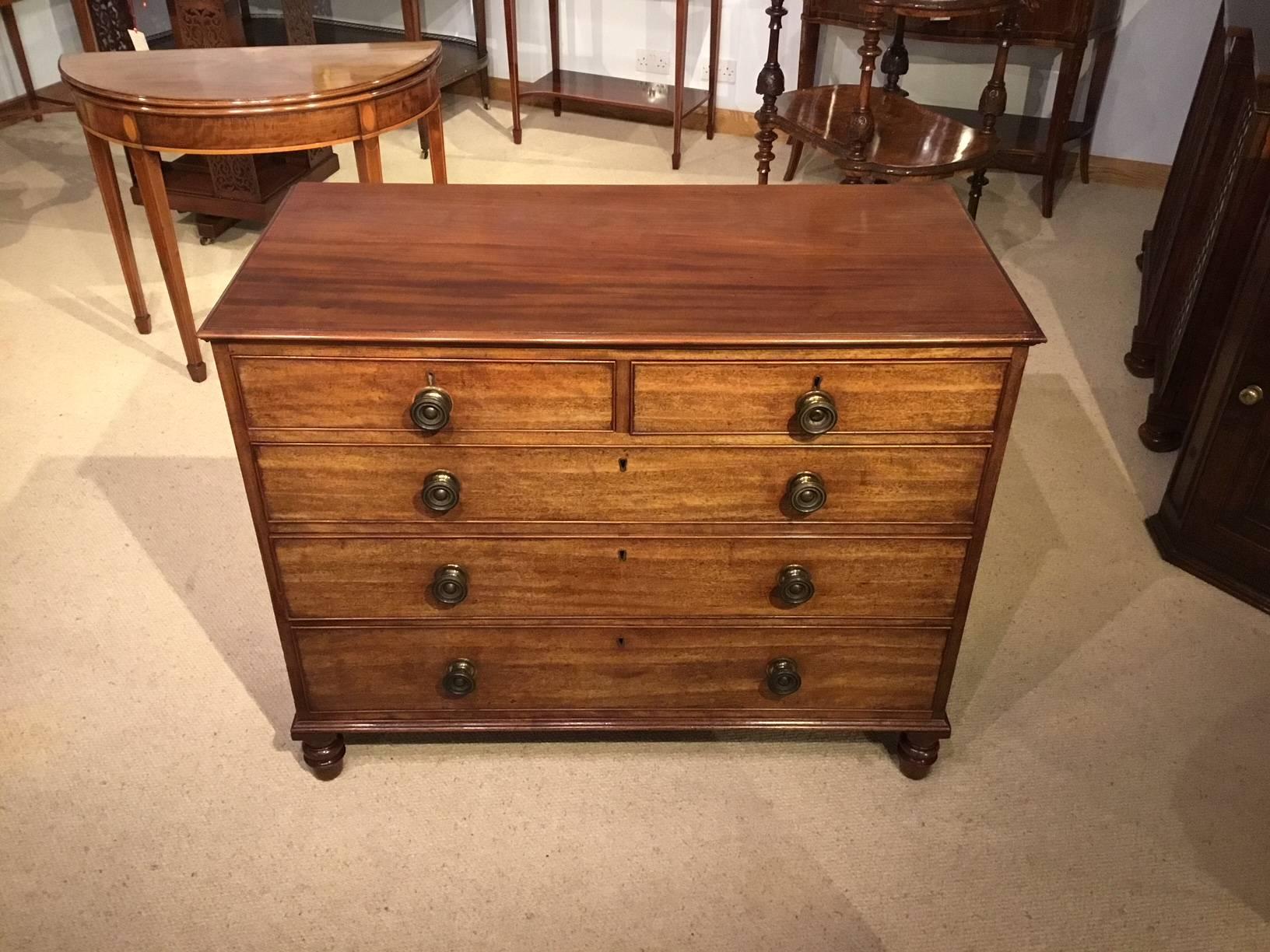 A mahogany Georgian chest of drawers by Gillows of Lancaster. Having a rectangular figured mahogany top above an arrangement of two short and three long oak lined drawers, retaining the original gilded brass knobs and with the original locks,