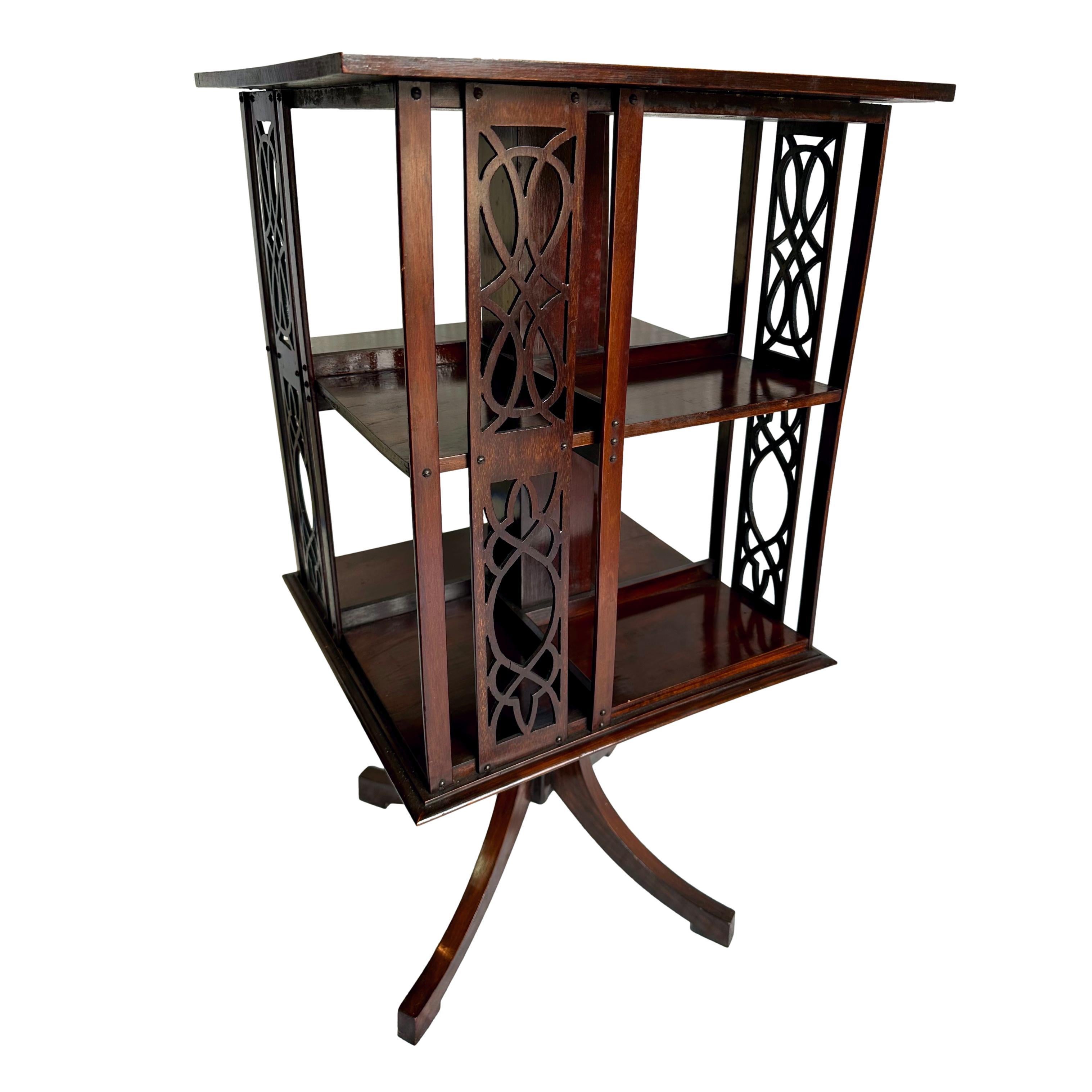 A Mahogany Revolving Bookcase, the figured mahogany top with satinwood banding, with Chippendale-style fretwork side panels, on a revolving tripod base, English, ca. 1900.  