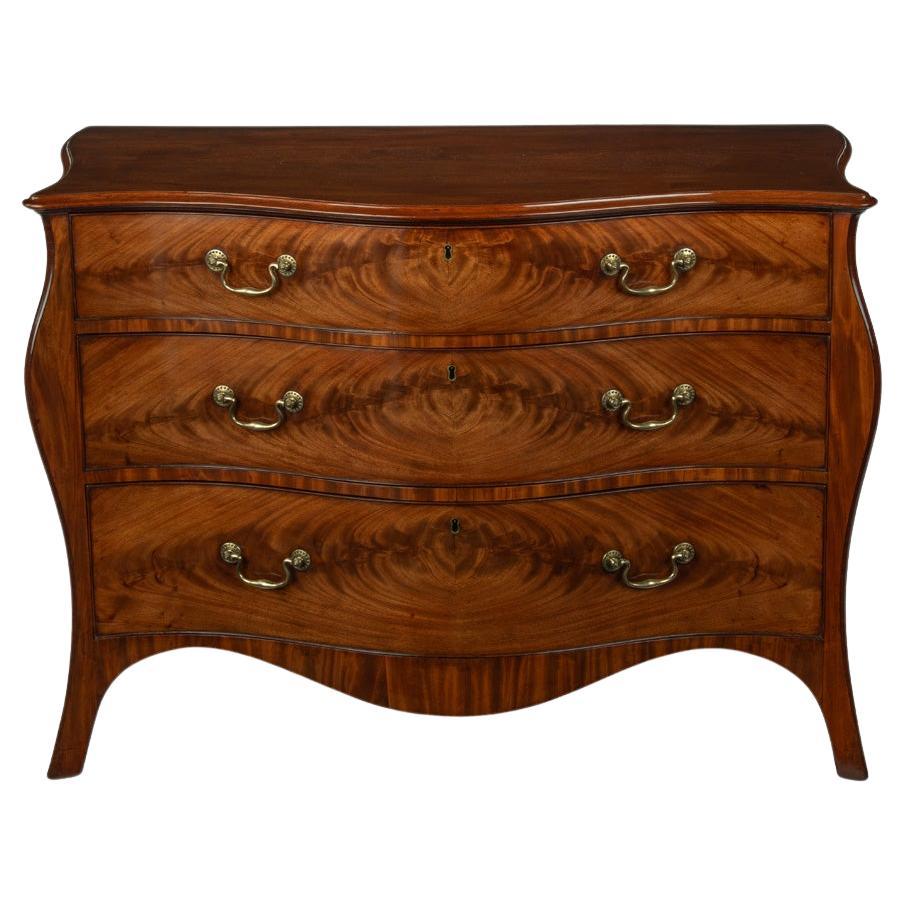 A mahogany three-drawer serpentine chest of drawers, attributed to Henry Hill For Sale