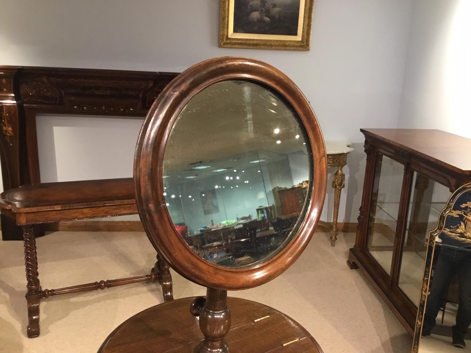 A mahogany Victorian period adjustable gentleman's shaving stand. Having a circular adjustable mirror above a central circular section with twin hinged compartments with satin birch interiors. Supported on a turned and fluted central column with