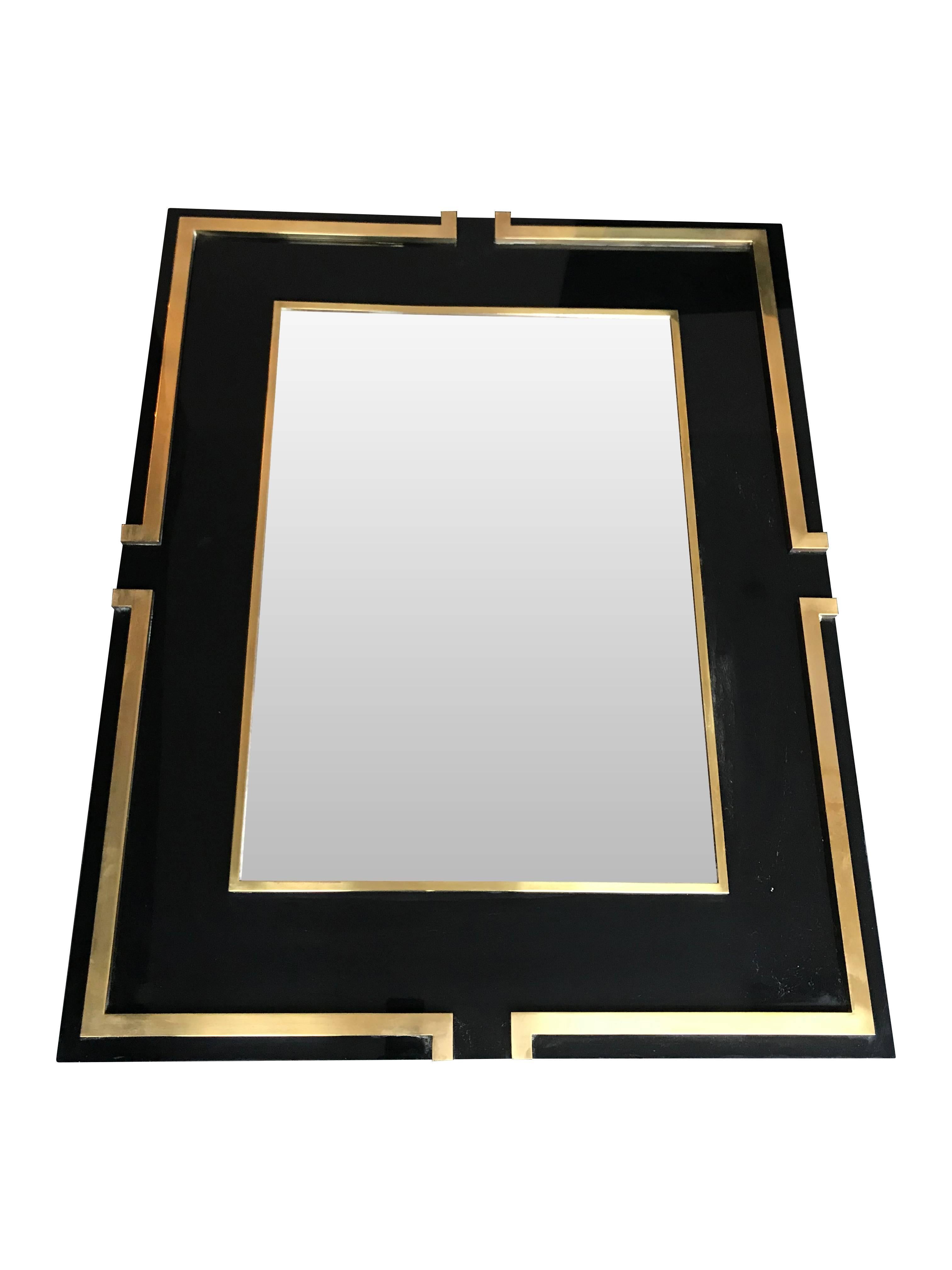 A Maison Jansen style black Lucite mirror with raised brass detail surround and internal frame.

 