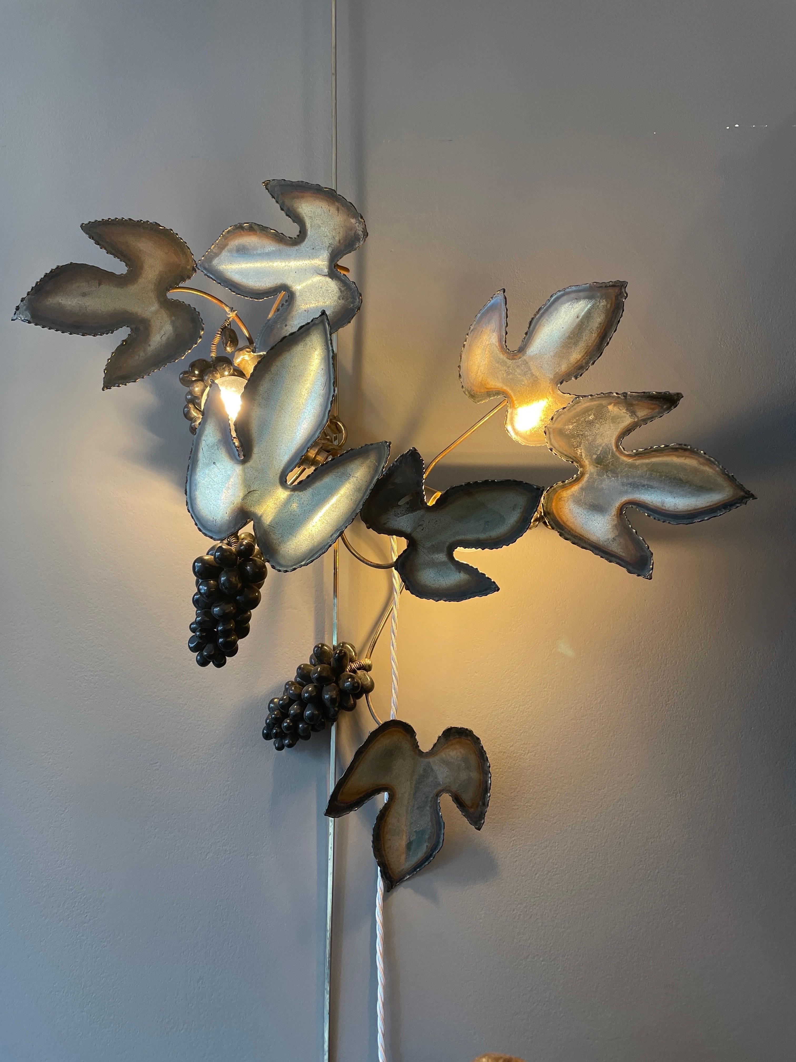 A burnished steel Vine wall light with foliage and black marble grapes. With two light fittings for illumination. Silver silk cord with inline switch. By Maison Jansen France. Matching table lamp also available. 

