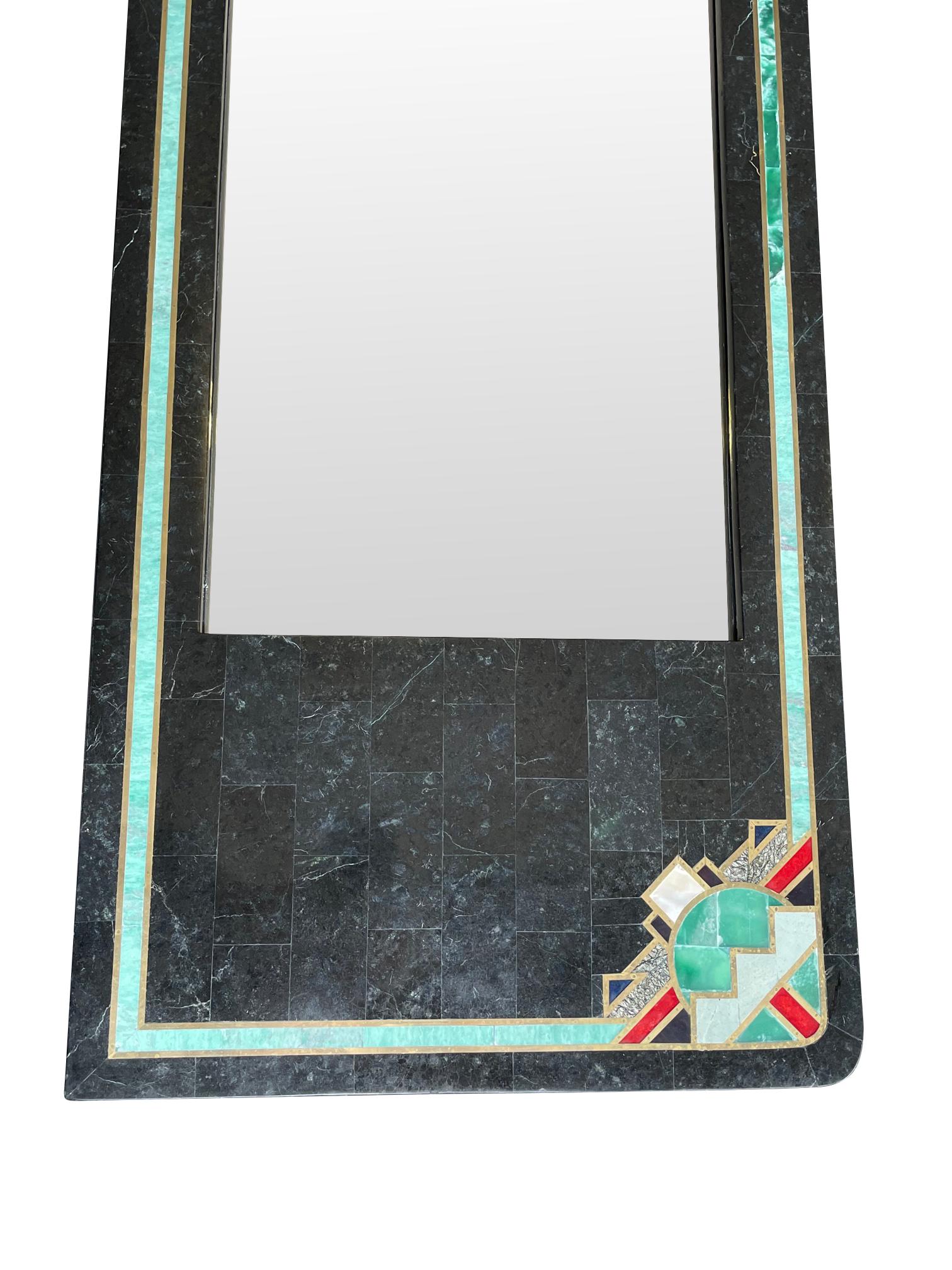 A Maitland Smith Art Deco style tessellated black marble mirror with turquoise and other coloured inlay set in a brass surround in an Art Deco style.