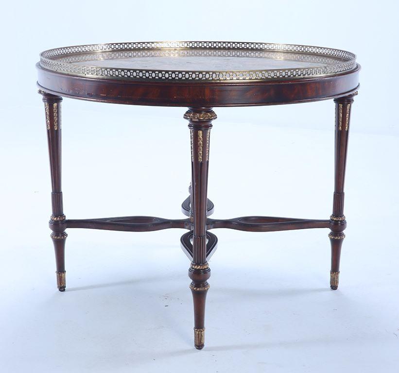 A Maitland smith crotch mahogany center table having a tessellated marble top with bronze gallery.