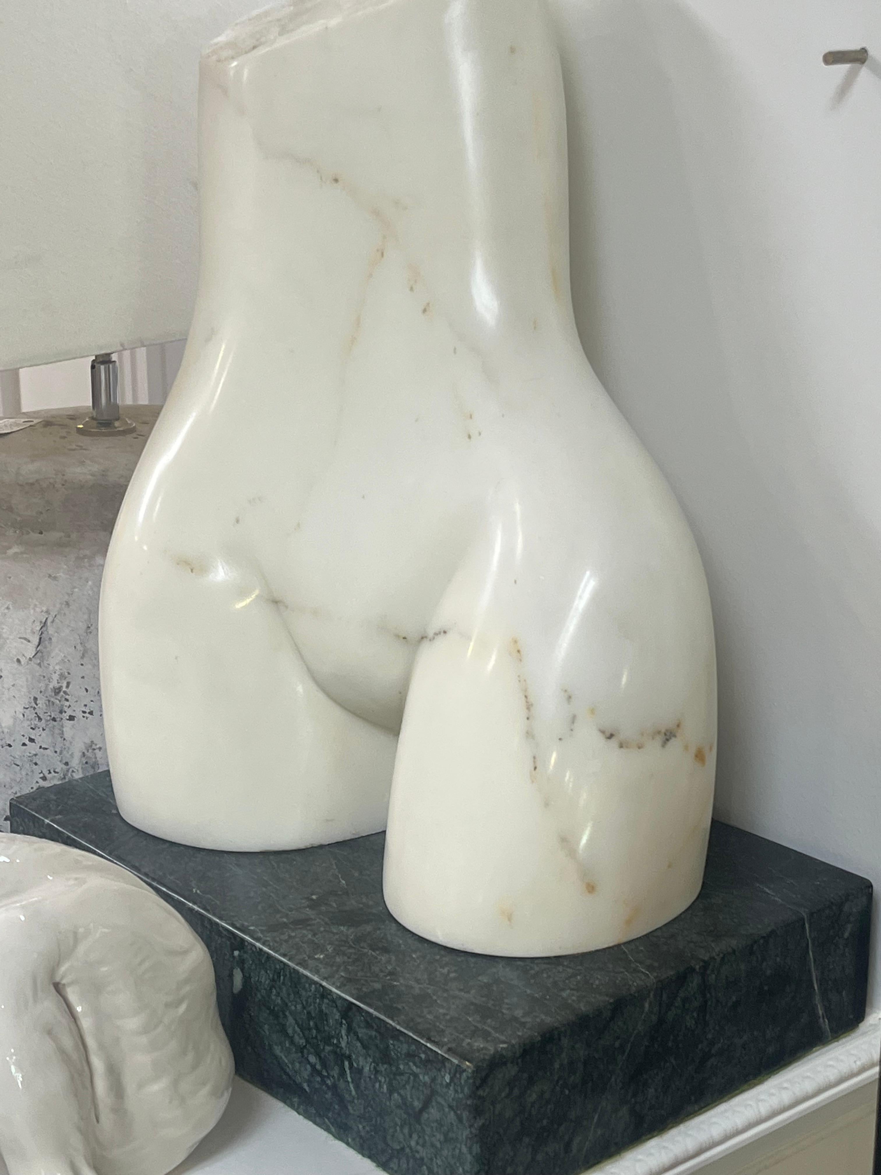 Ce demi-torse à la forme humaine sophistiquée est réalisé en marbre blanc italien poli par John Bartolomeo, (américain, 1923-2012) qui était également architecte dans la région de Chicago. et a conçu le célèbre Drury Theater. et d'autres bâtiments