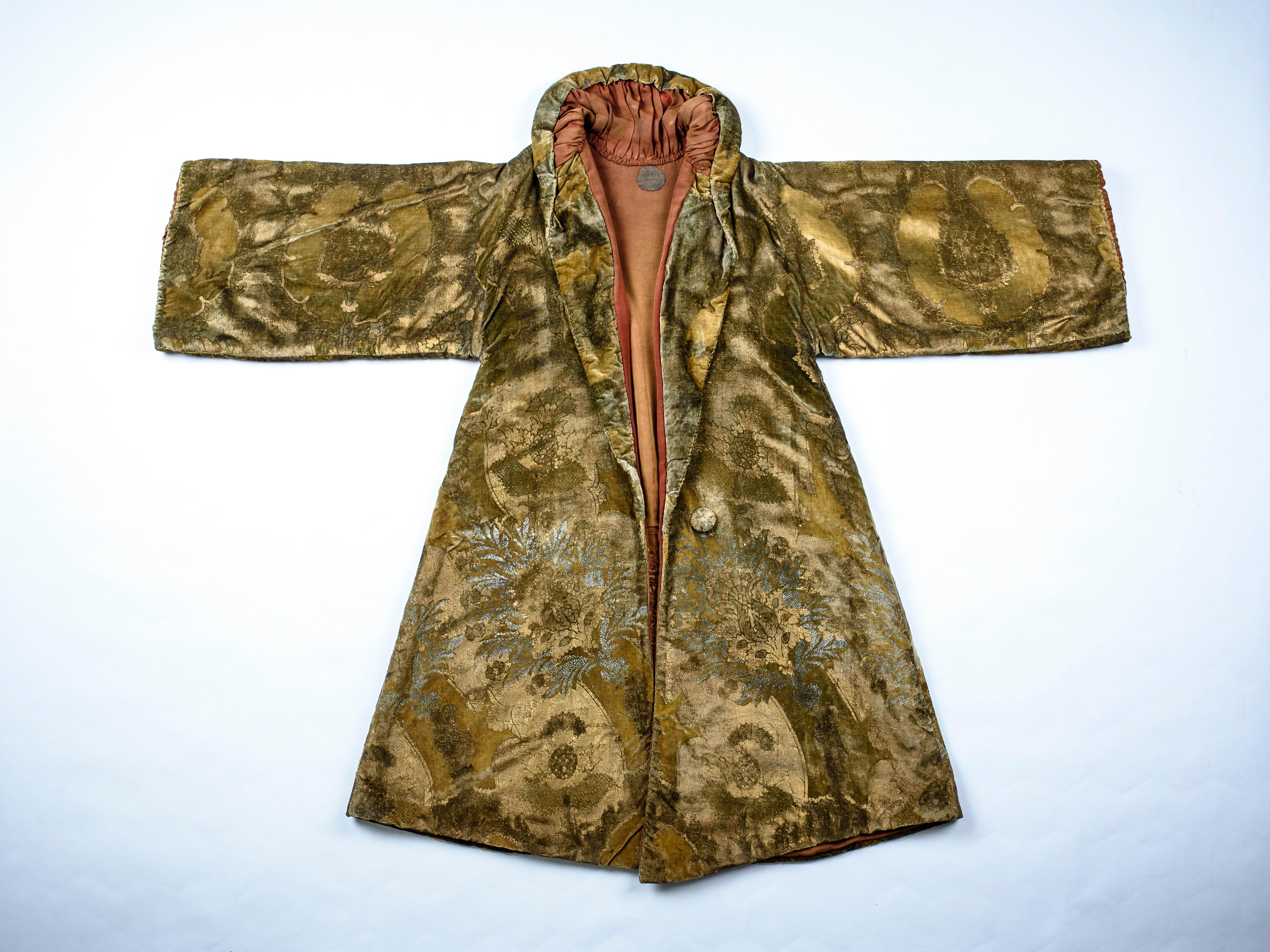 Circa 1920-1930

Italy - Venice

Ample winter coat for the evening in green-yellow velvet printed with gold and silver woodblock and signed Mariano Fortuny Venice. It borrows from the Italian Renaissance the famous pomegranate and pineapple motif
