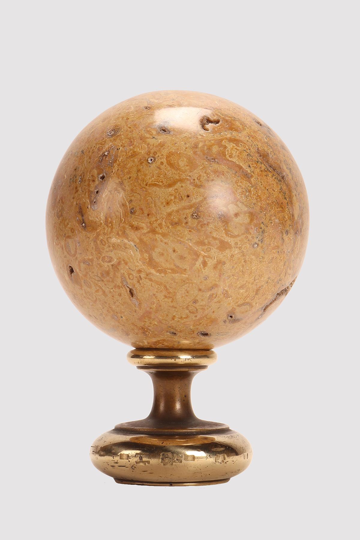 A marine fossil “Mothership” sphere, resting on a base, made of brass. Italy circa 1890.