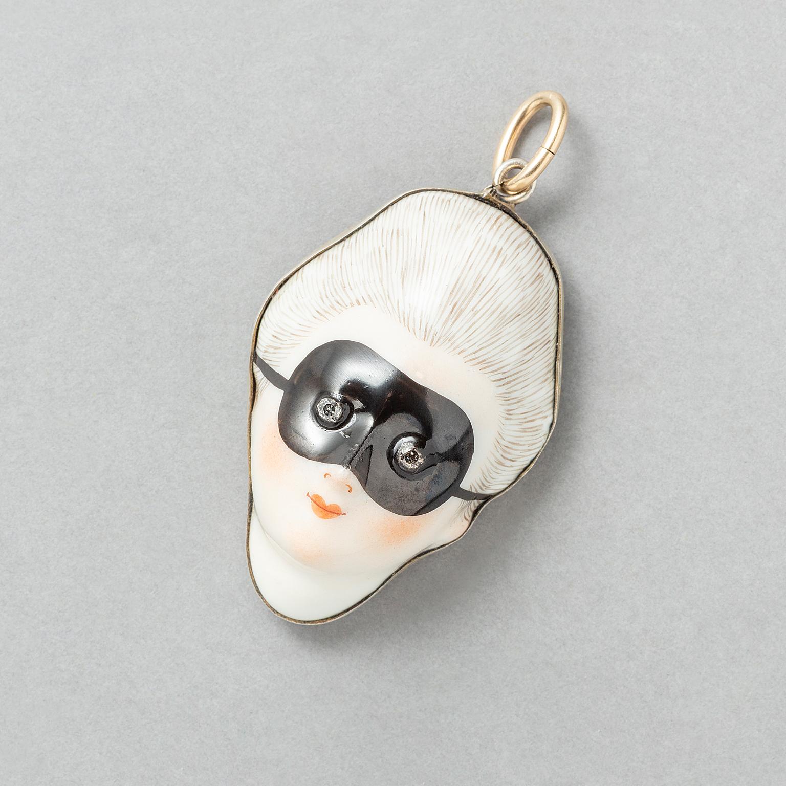 A porcelain and silver gilt patch box pendant with a 14k gold bail featuring a masked lady with rose cut diamond eyes, France, early 19th century marked with the boar’s head for silver and with a French makers mark.

weight: 19.7 g
dimensions: 5.8 x
