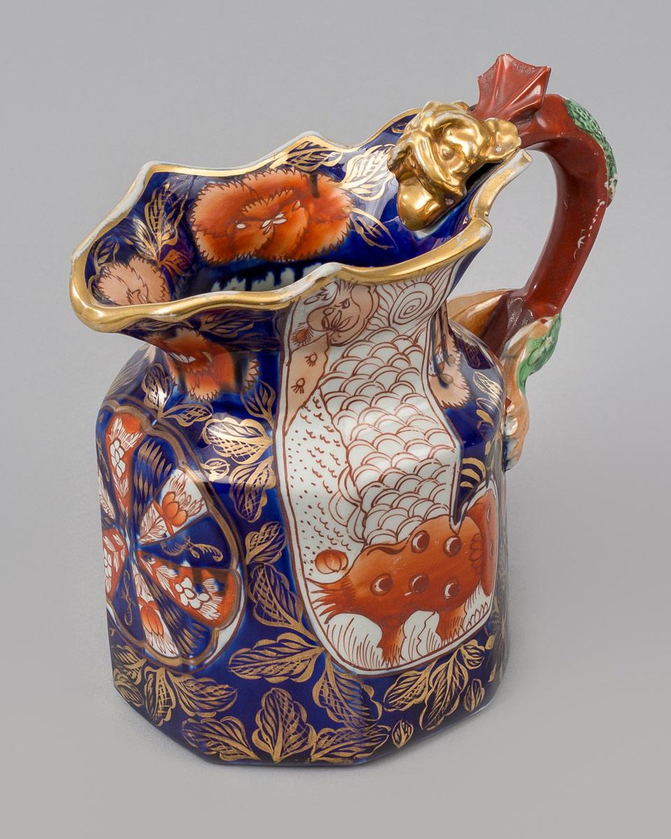 A Mason’s ironstone China jug decorated in the “Elephant’s Foot” pattern, with well-defined dragon handle with gilded head, glazed in the Imari colors of cobalt, orange and gilding. The base has the round impressed mark for Mason’s.