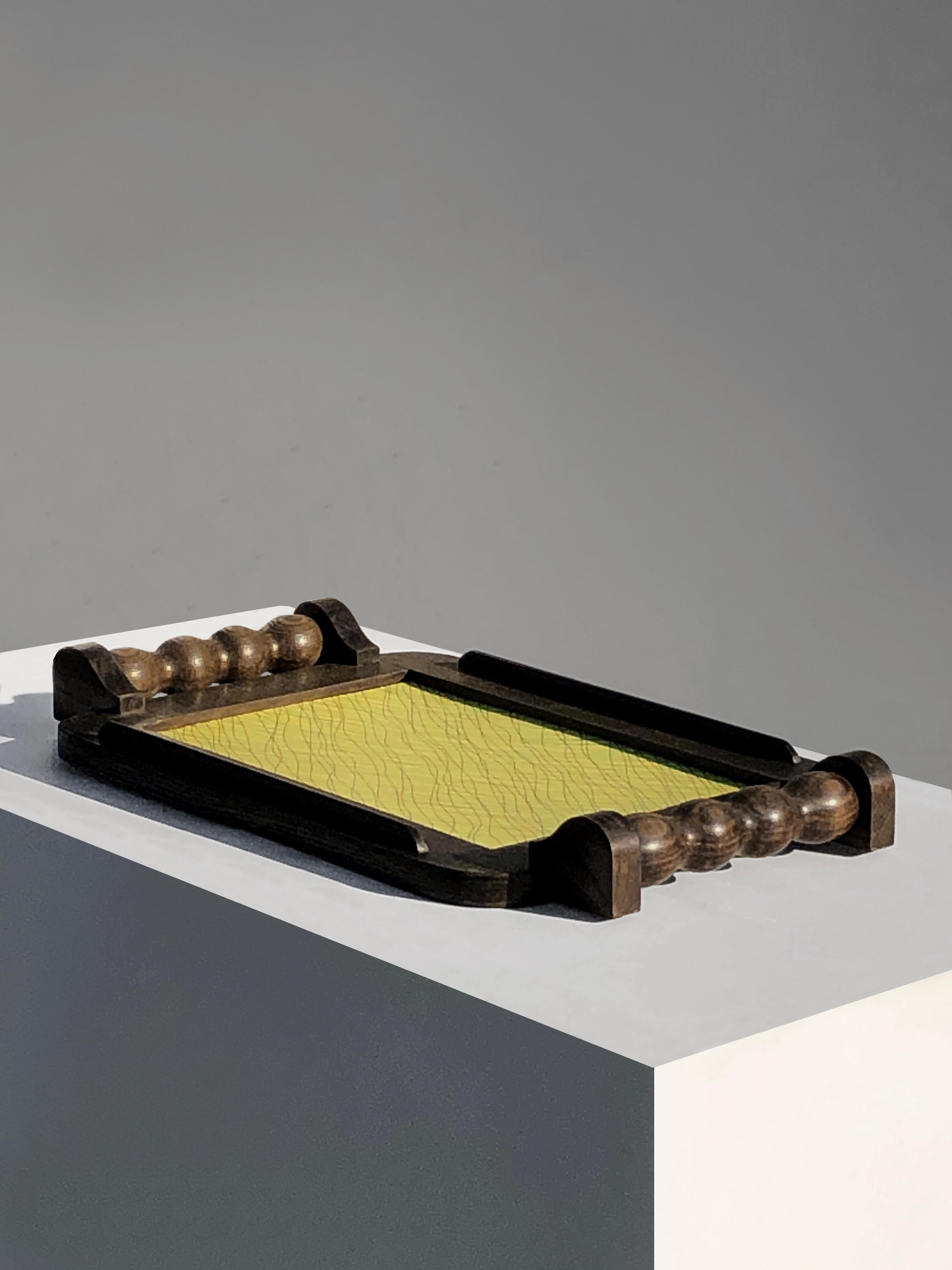 Placa rectangular grande y rigurosa, Art Decó, Modernista, Brutalista, de madera gruesa de ébano con impresionantes y sensuales asas, que forma un fuerte marco alrededor de la zona central con un bonito y gráfico dibujo amarillo, atribuida a Charles